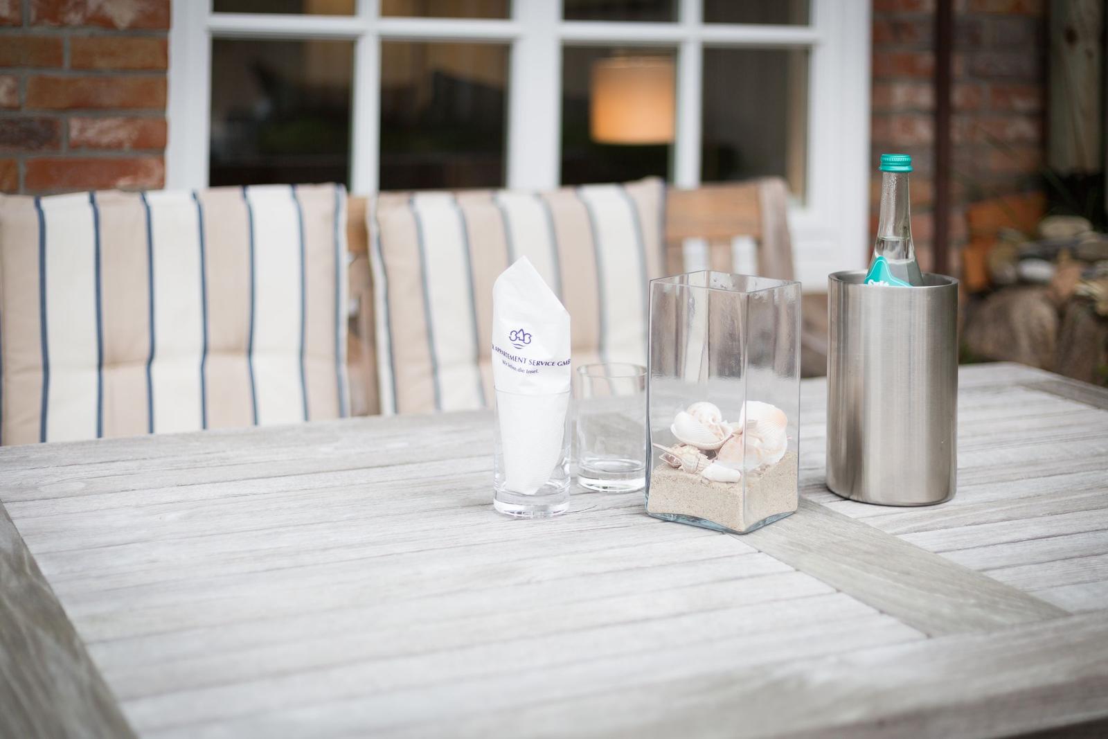 Wooden table with drinks and shell terrarium outdoors