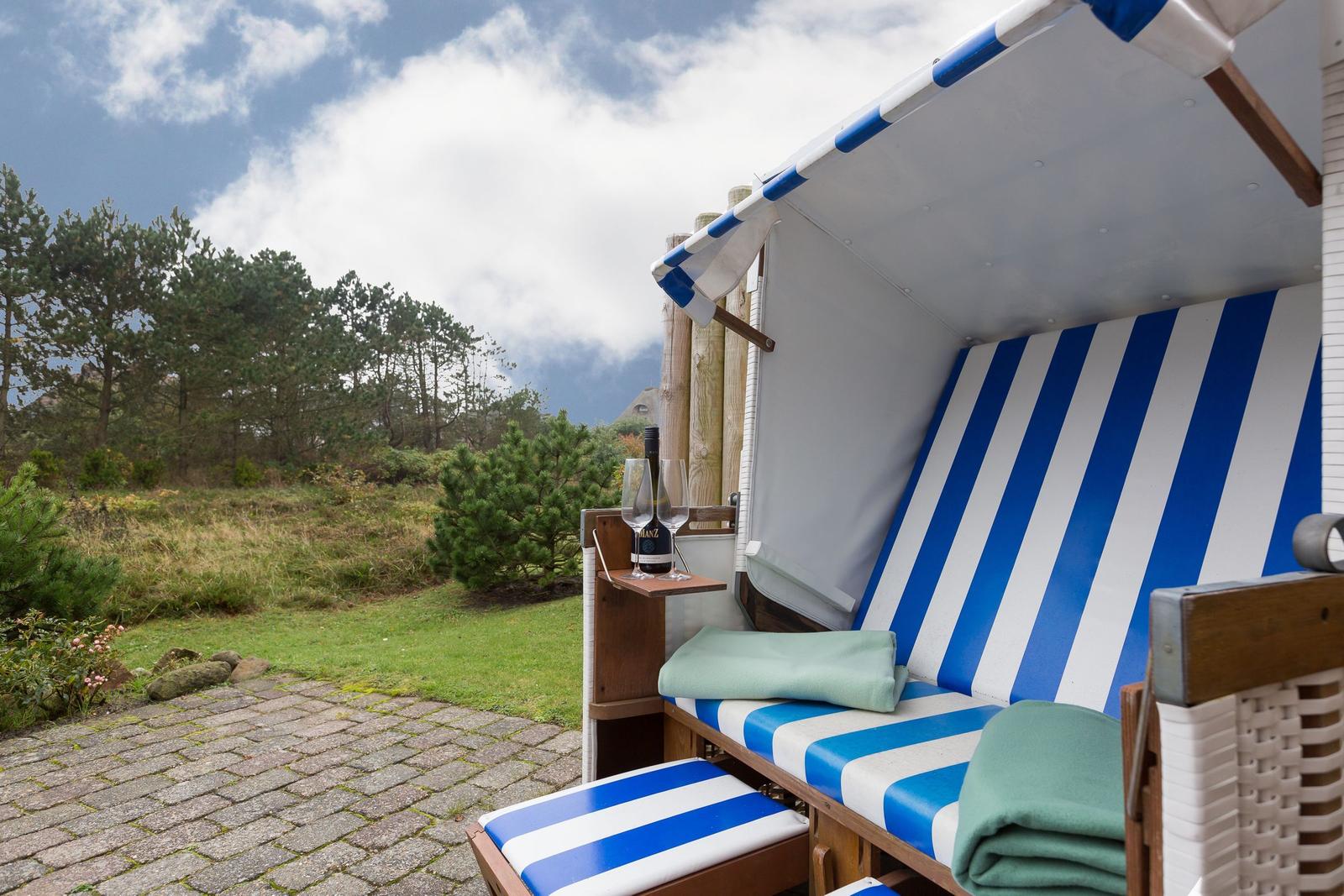 Blue-and-white beach chair with drink and green towels in the garden