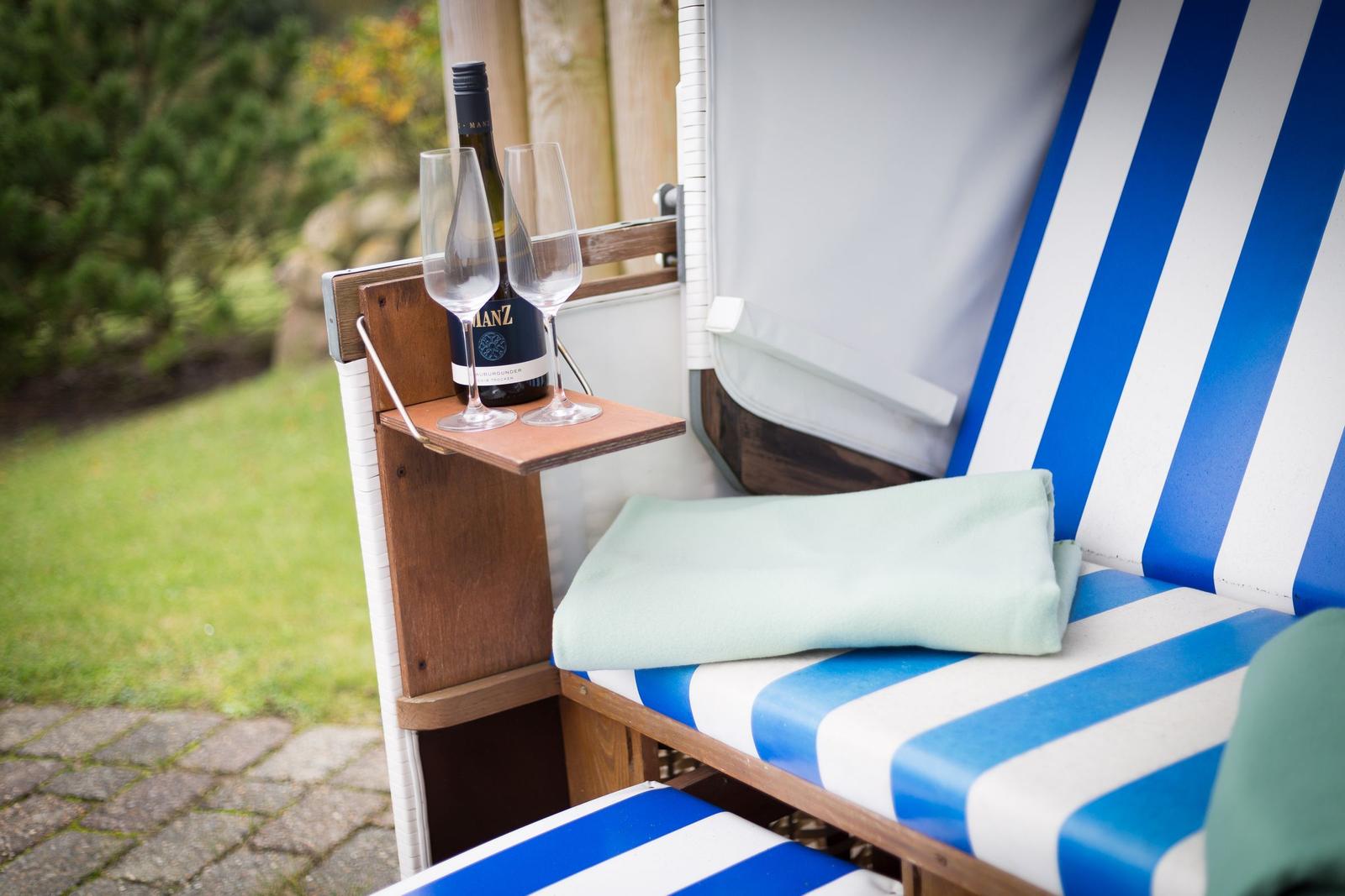 Blue-and-white lounge chair with drink and towel in the garden