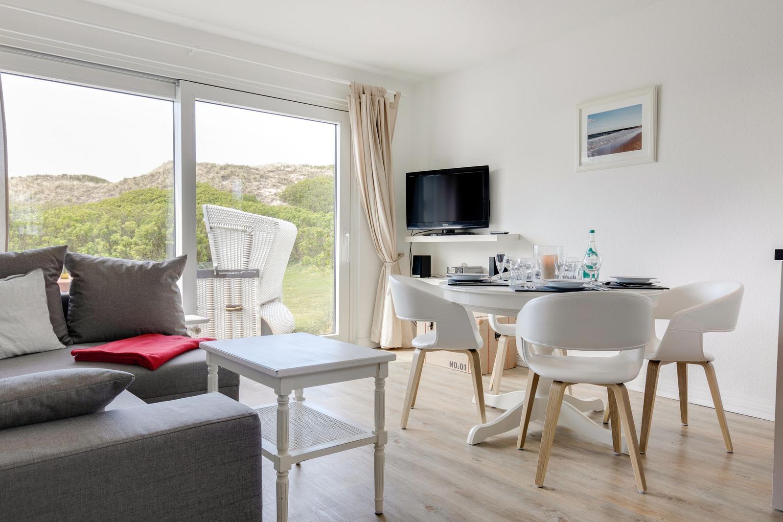 Living and dining area with TV and view of the dunes.