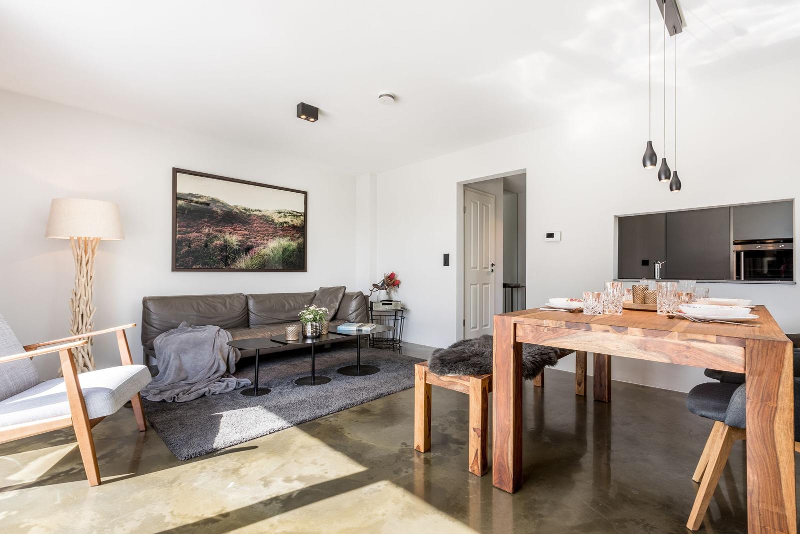 Wohn- und Essbereich mit Sofa, Esstisch und Küchenbereich.