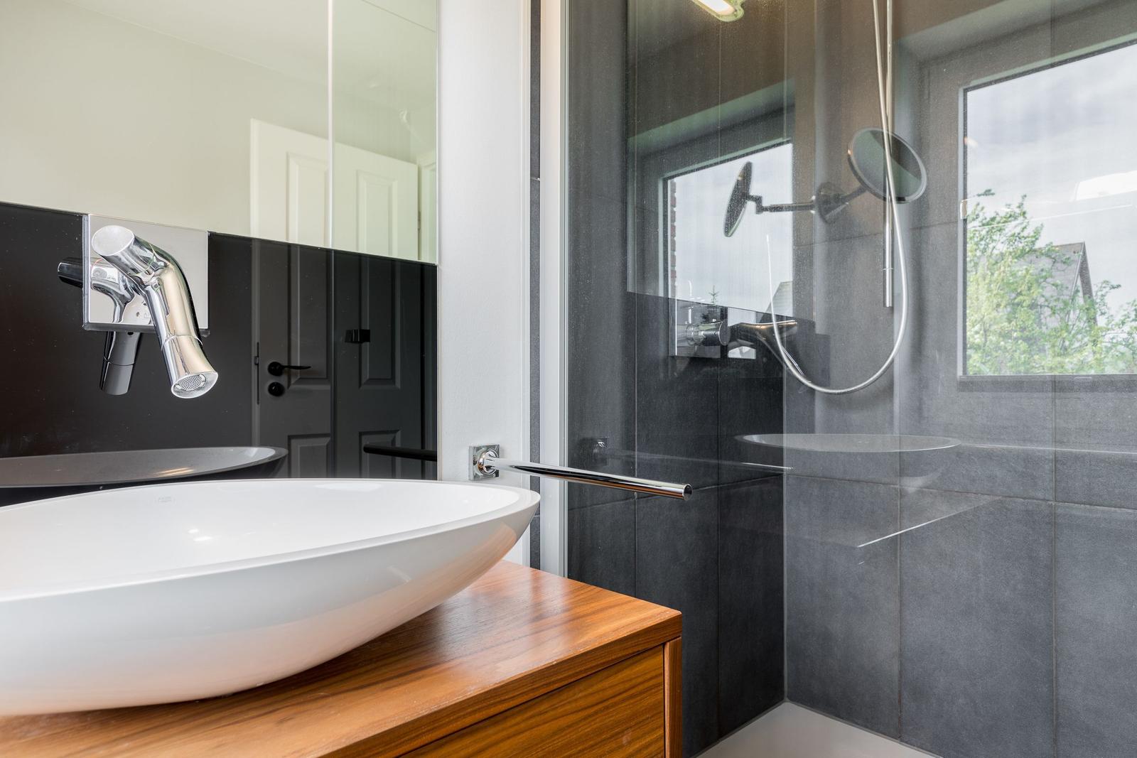 Badezimmer mit Dusche, Waschbecken und Fenster