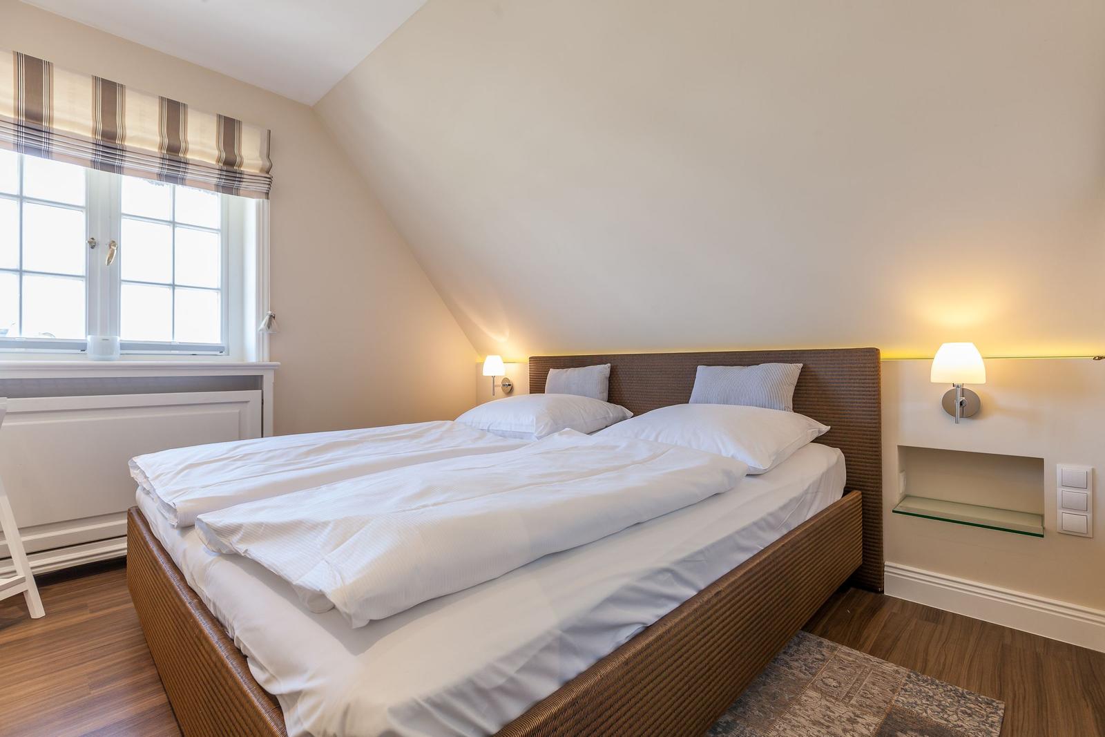 Bedroom with double bed, window, and nightstands.