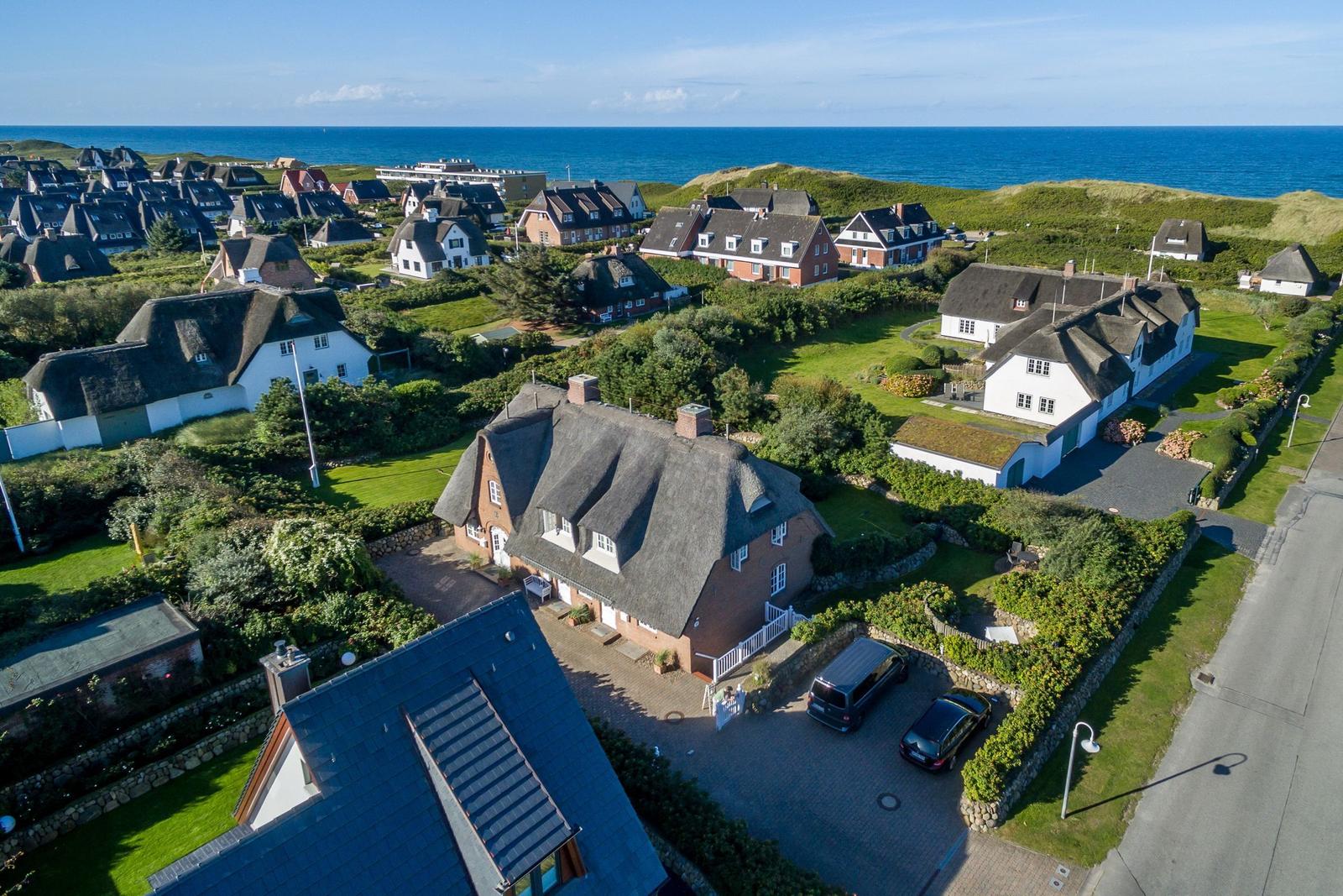 Village with thatched houses and view of the sea.