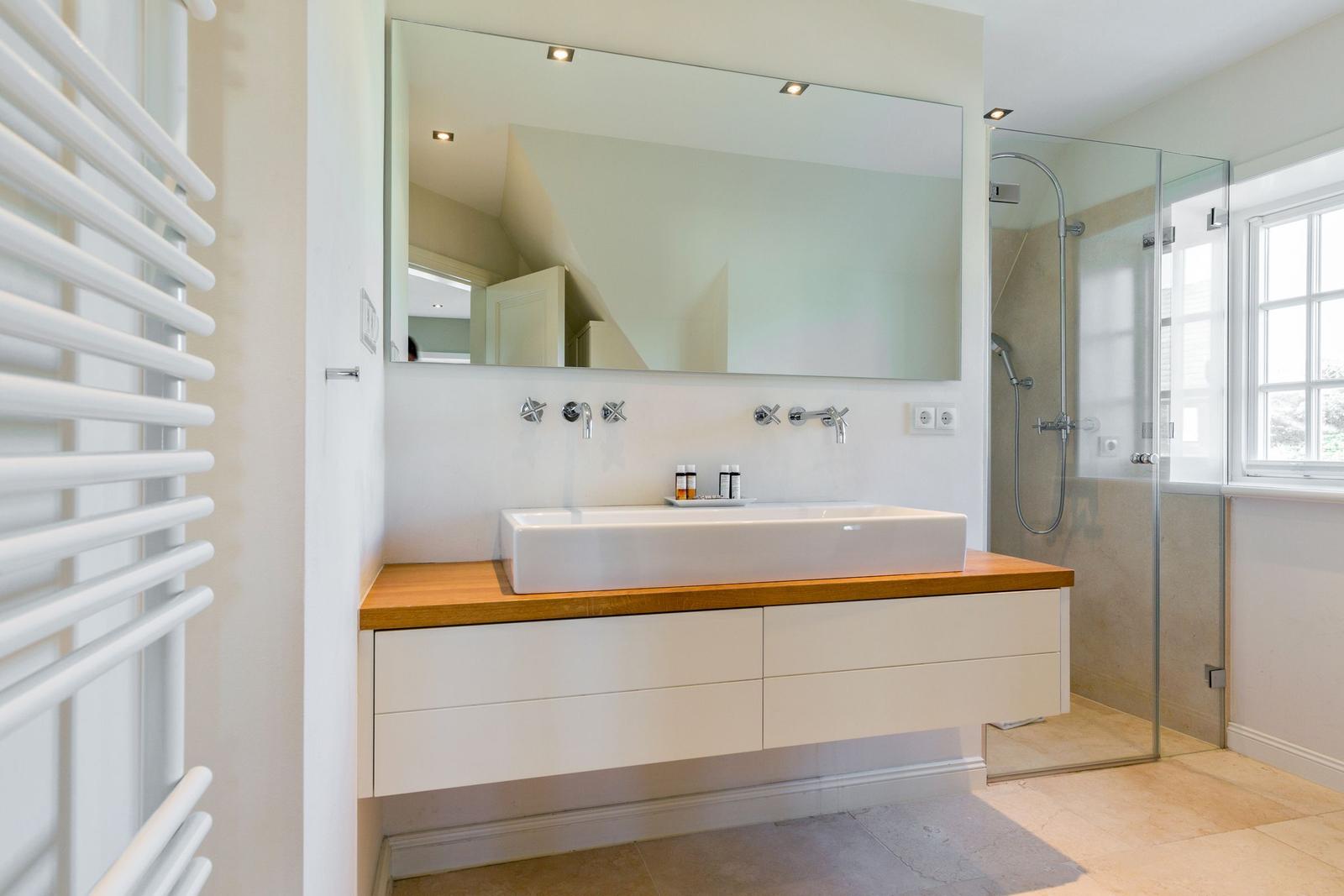 Badezimmer mit Waschtisch, Spiegel und Dusche