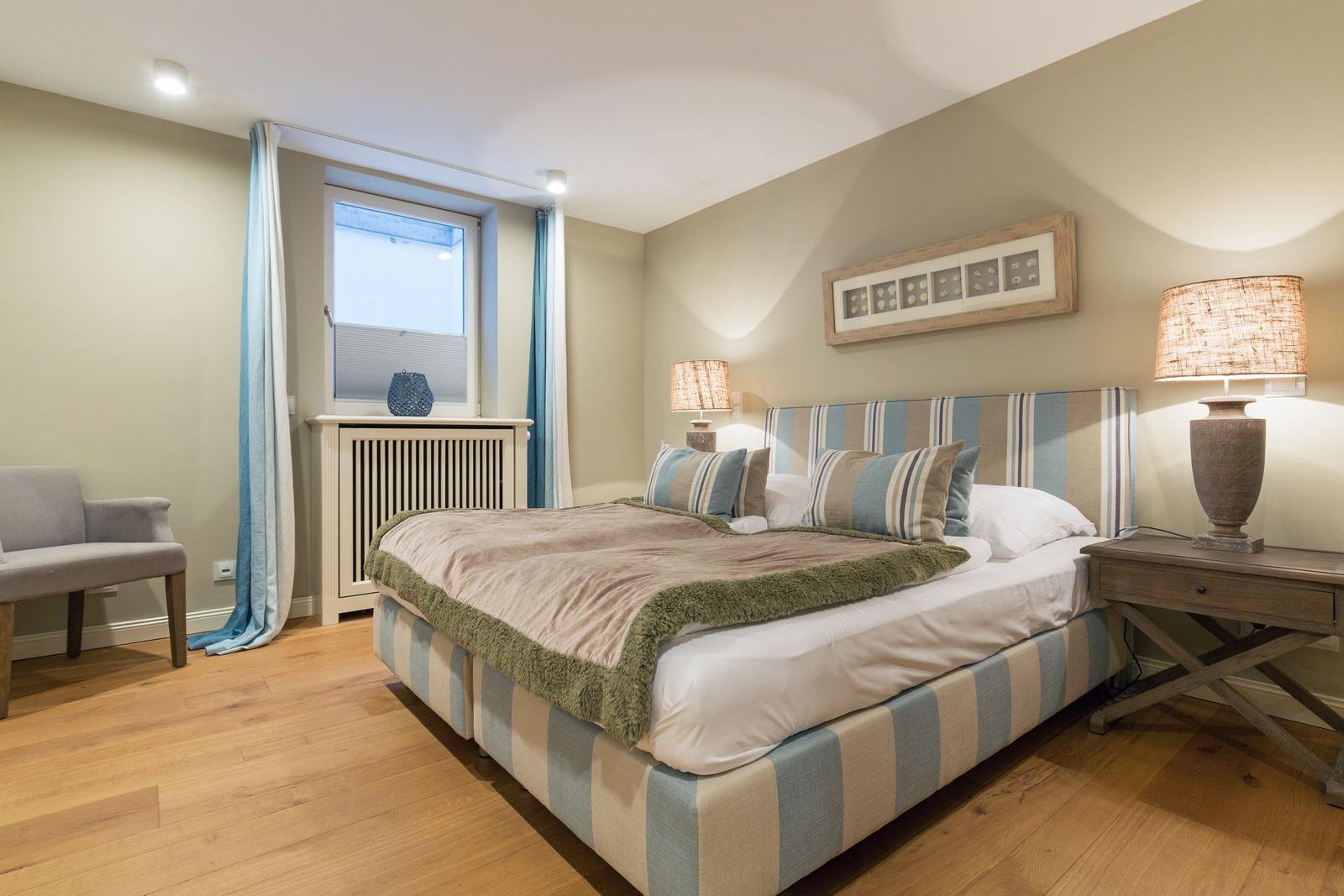 Schlafzimmer mit Bett, Nachttisch und Fenster