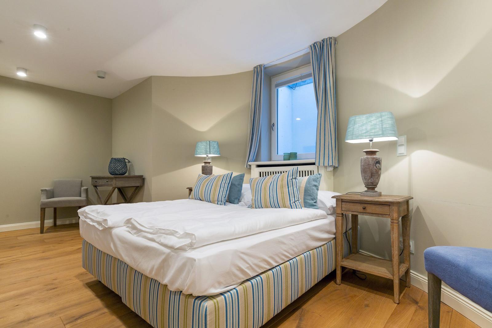 Schlafzimmer mit Bett, Nachttisch und Fenster