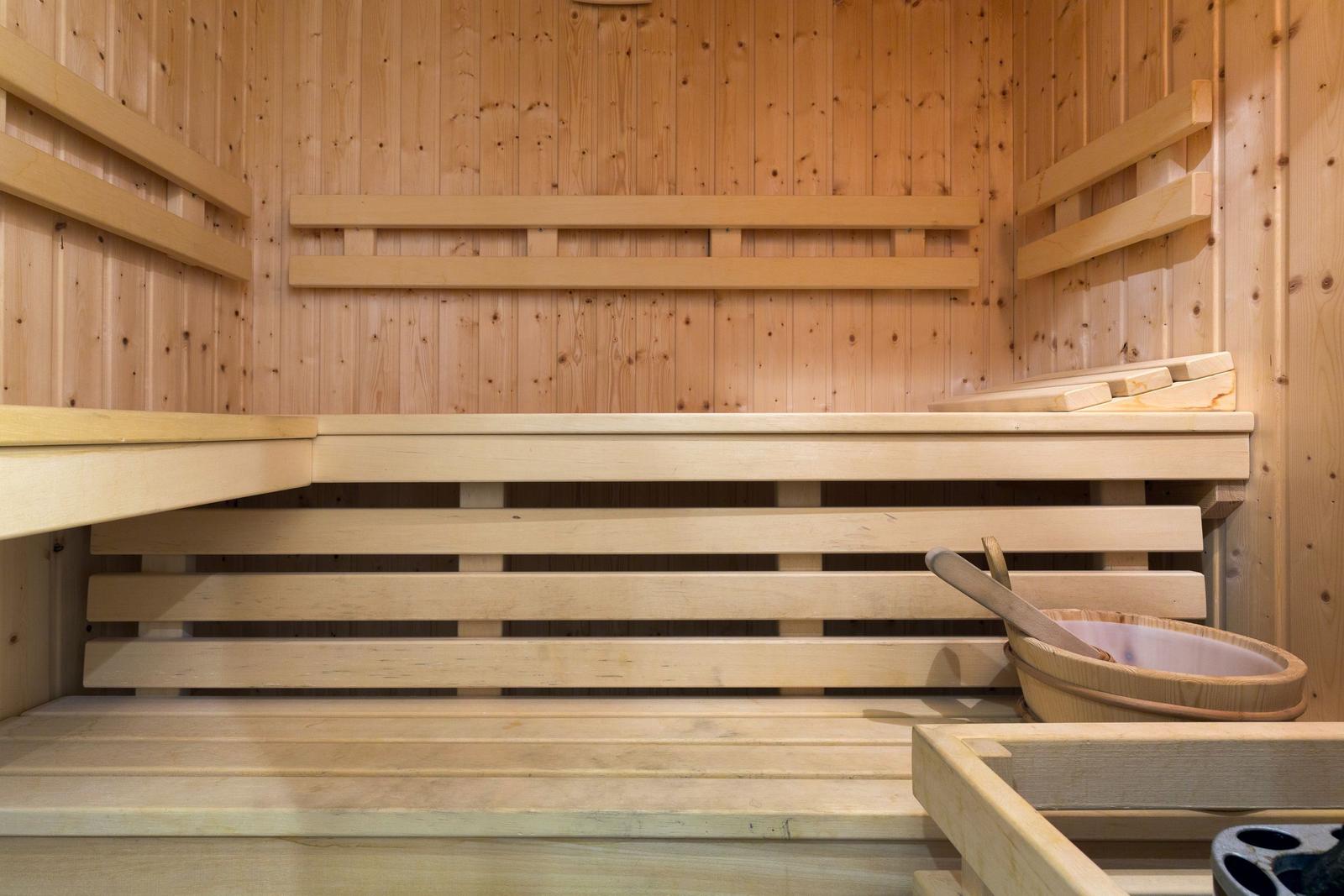 Holzsauna mit Sitzbänken und Eimer