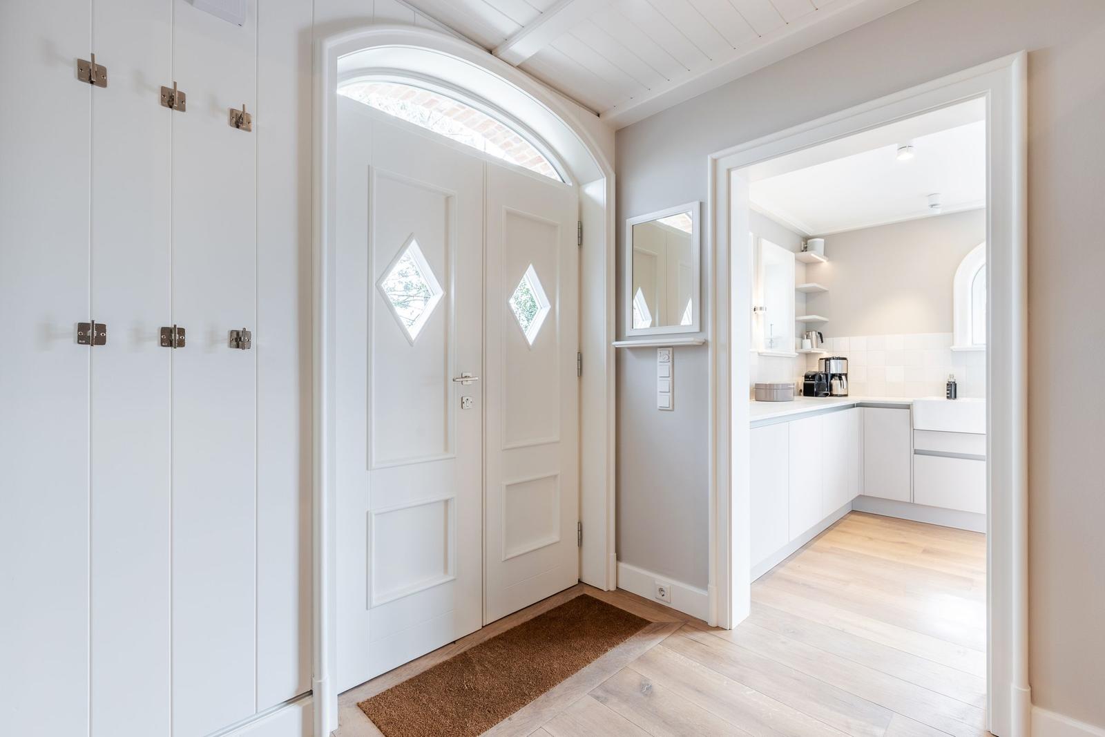 House with entrance door, closet, and view into the kitchen.