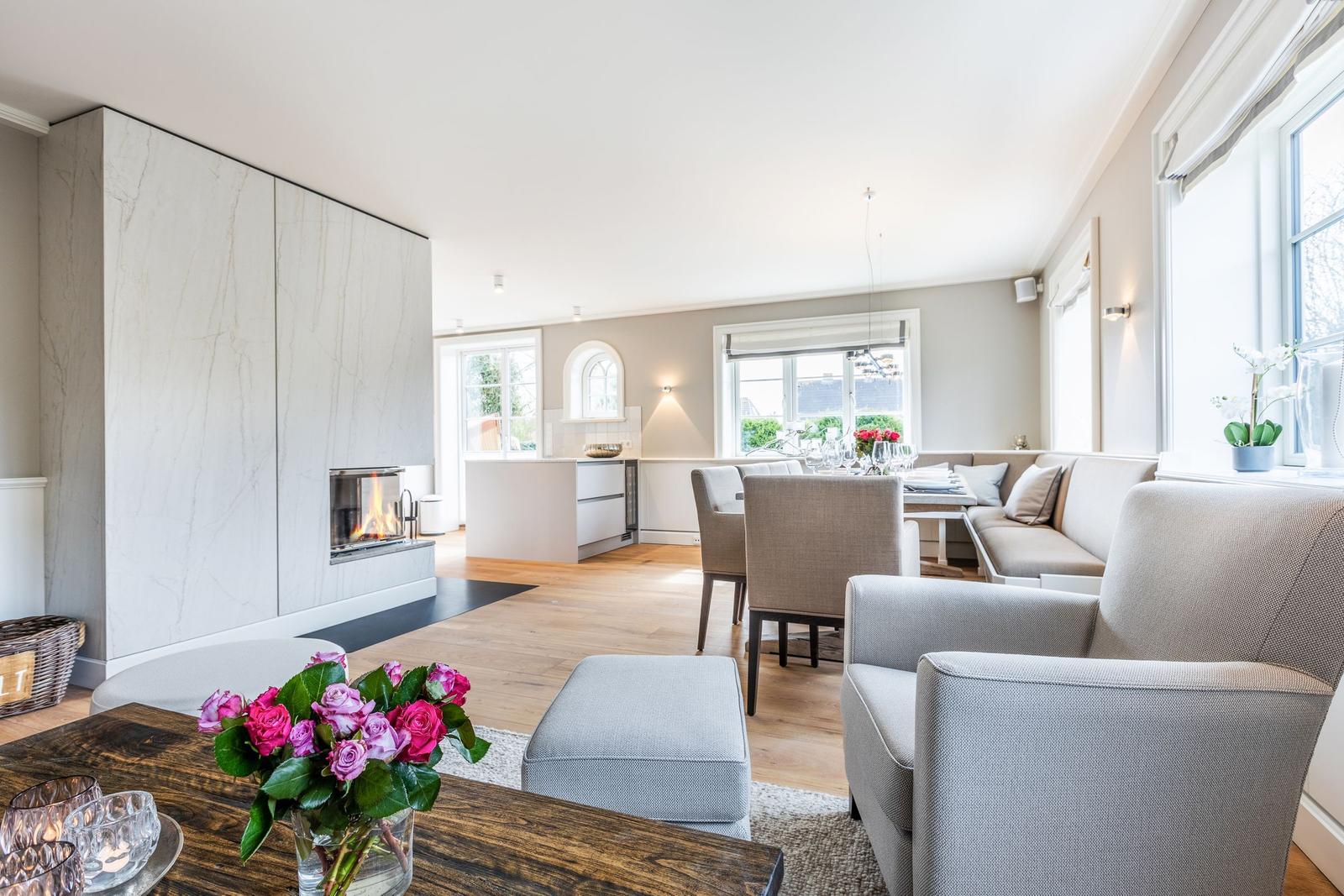 Living and dining area with fireplace, seating, and windows.