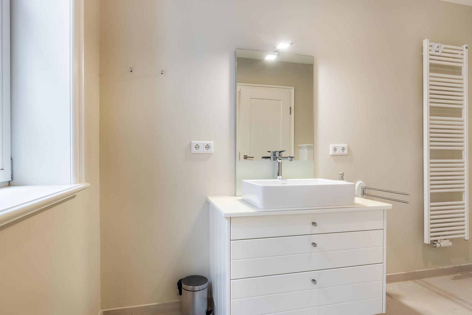 Bathroom with sink, mirror, and heater