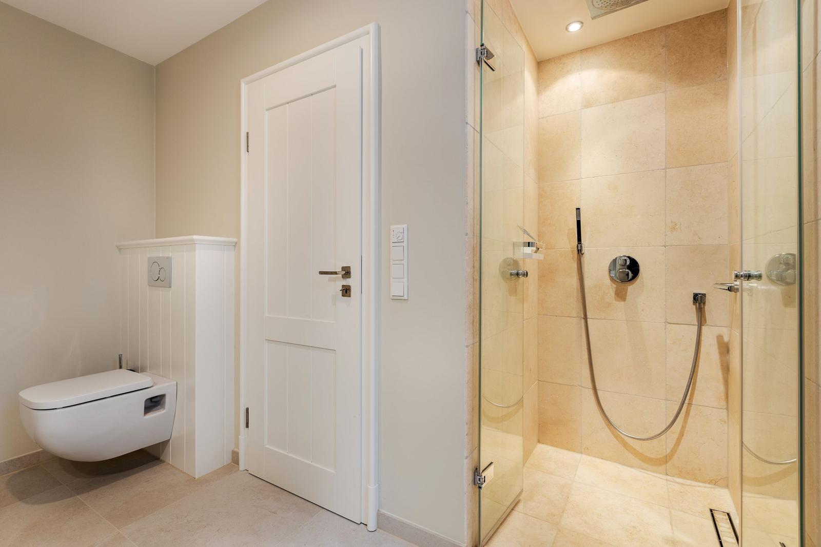 Bathroom with shower and wall-mounted toilet
