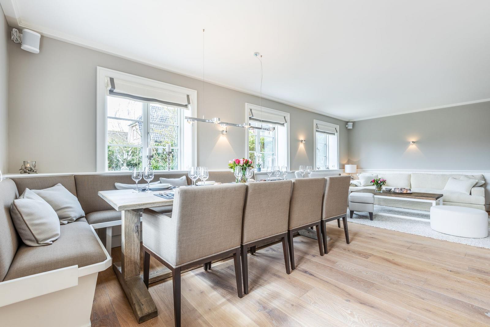 Dining room with bench, table and chairs. Living area with sofa and coffee table.