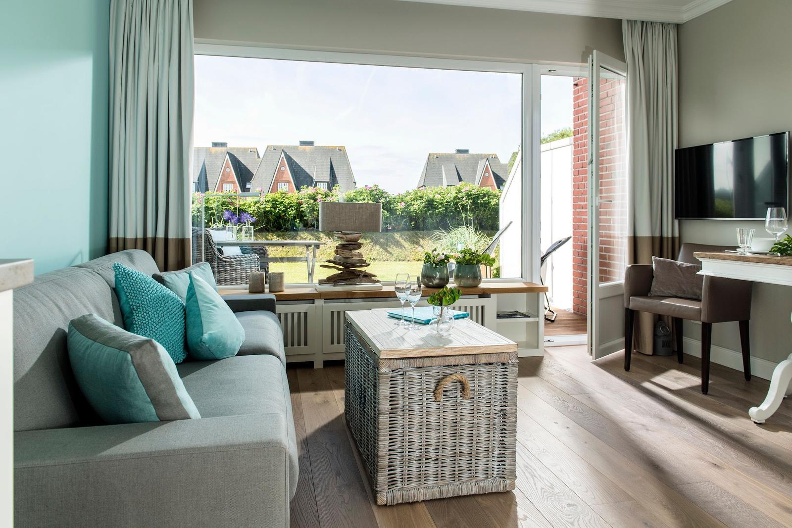 Living room with sofa, coffee table, and garden view