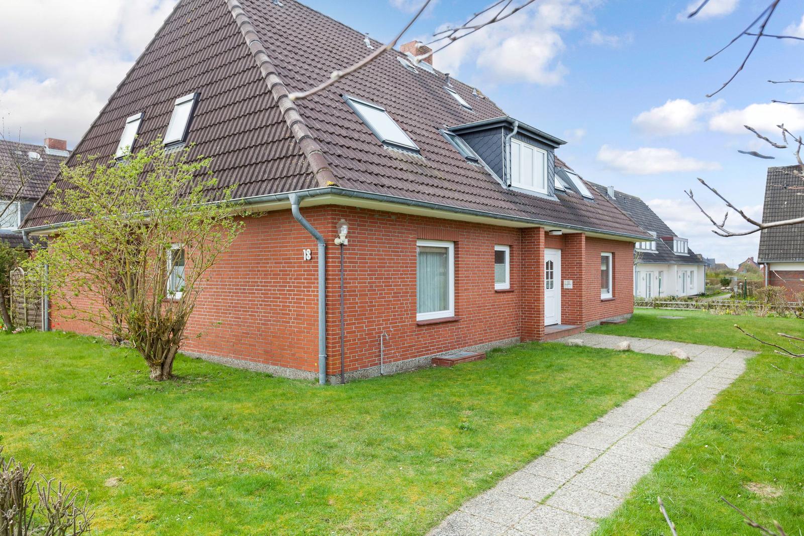 Red brick house with skylights and garden path.