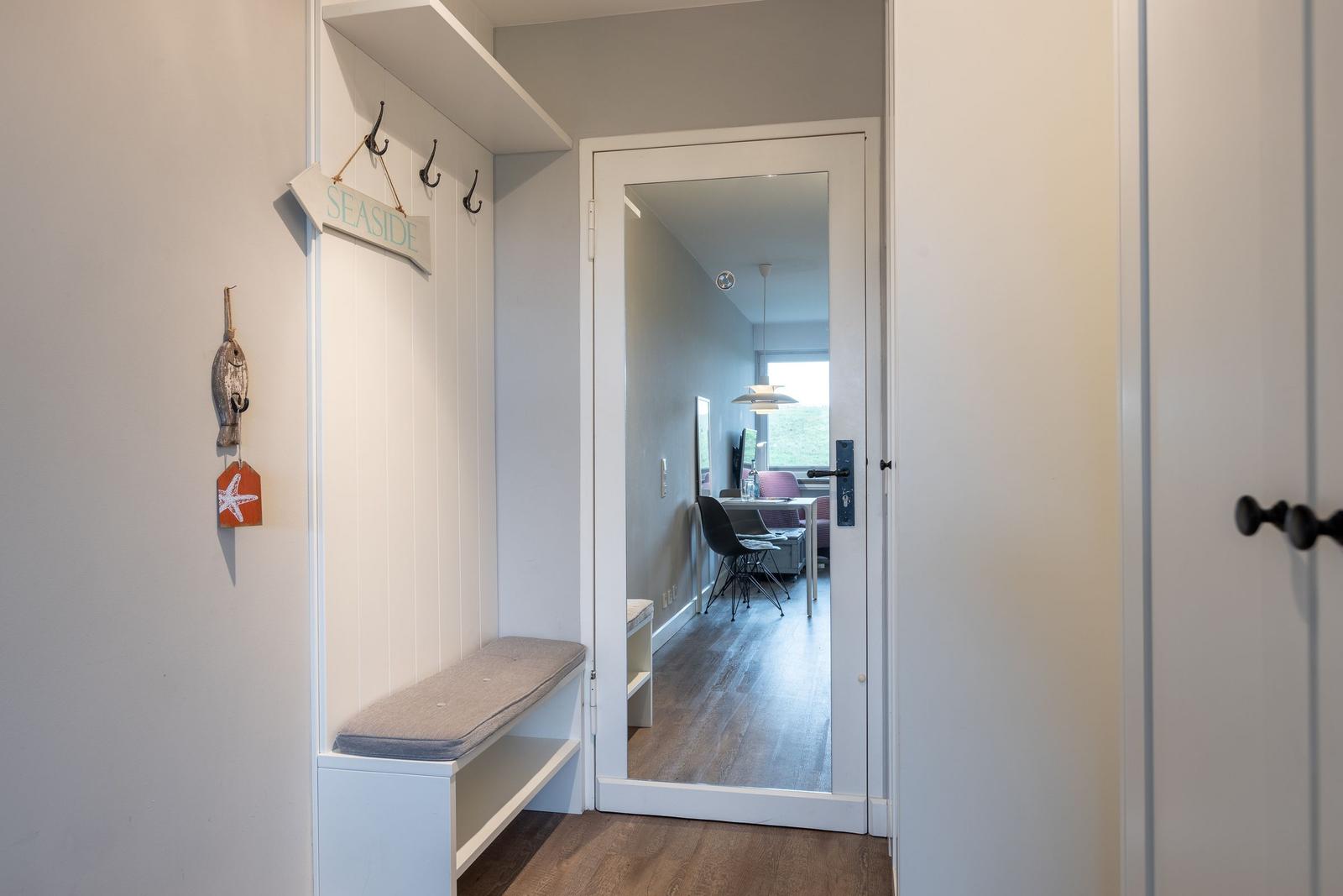 Entrance with bench, hooks, and mirror. Corridor to the kitchen.