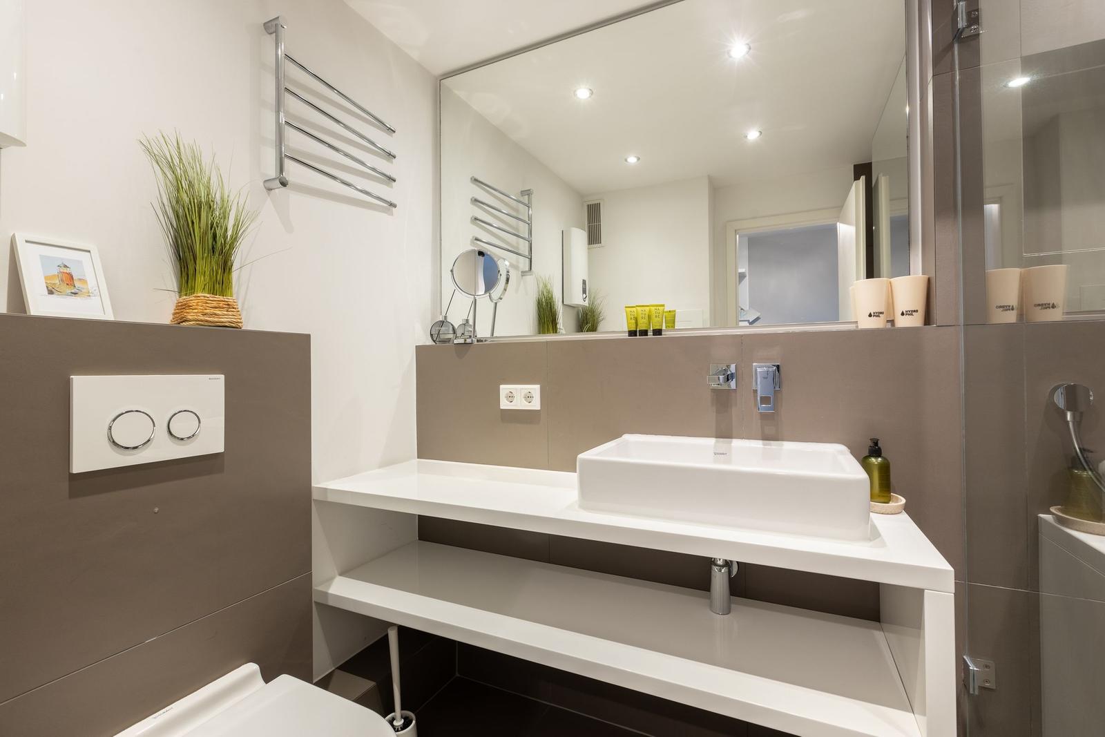 Bathroom with sink, mirror, and toilet.