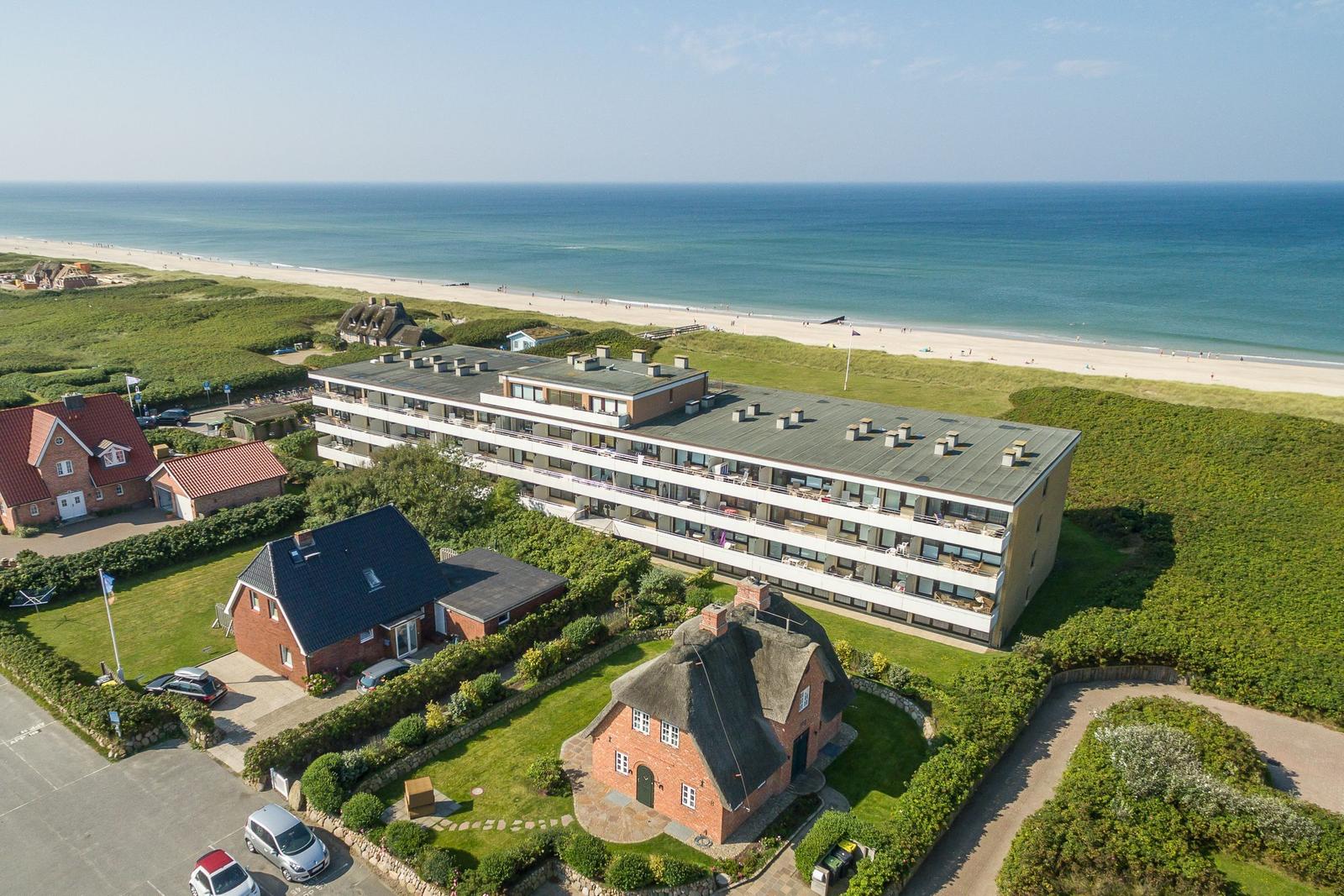 Holiday complex near the beach with multiple buildings and green areas.