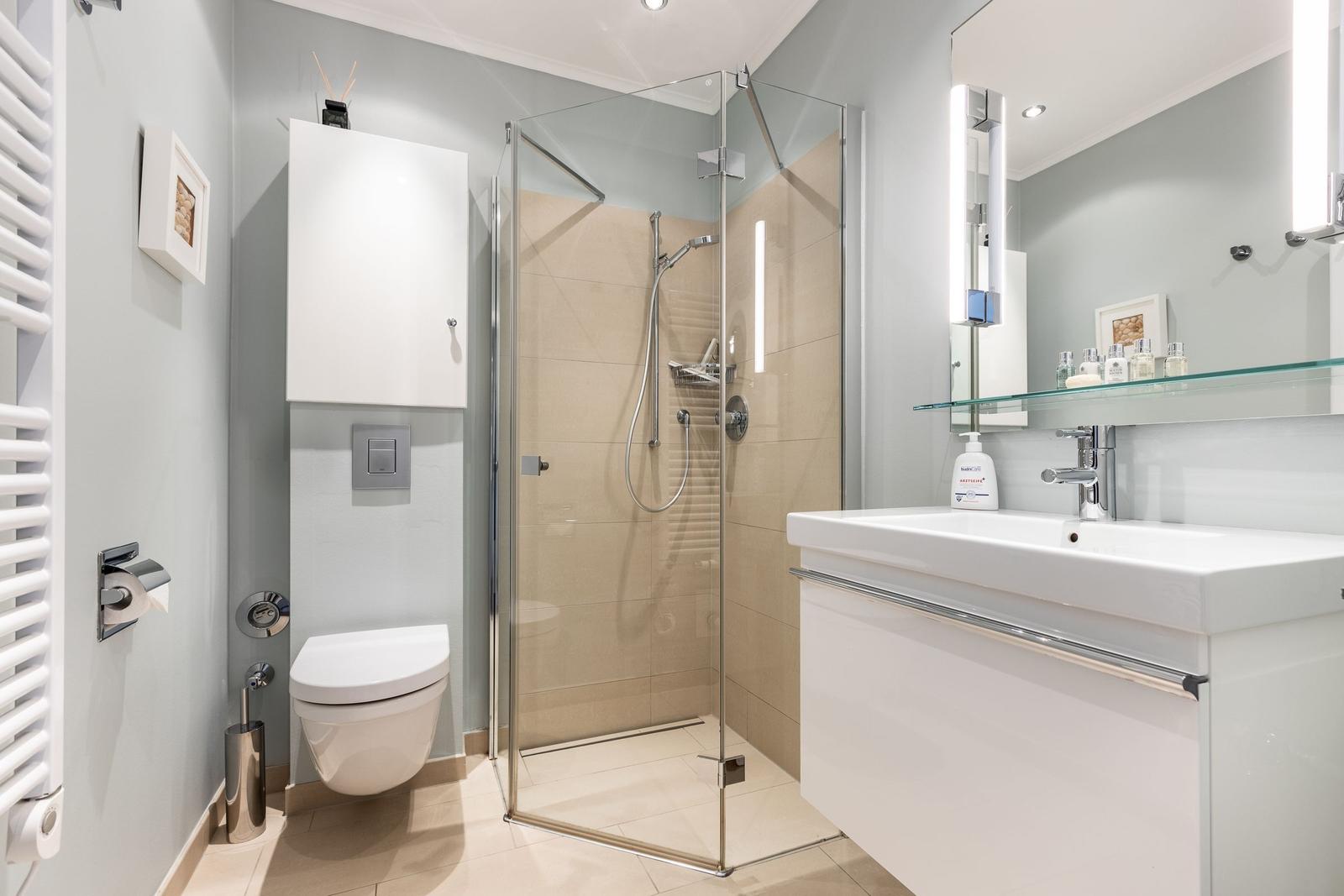 Badezimmer mit Dusche, Waschbecken und Toilette
