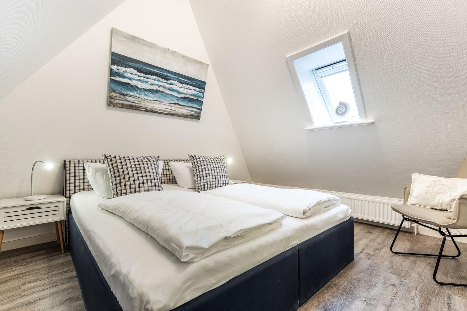 Schlafzimmer mit Doppelbett, Fenster und Wandbild
