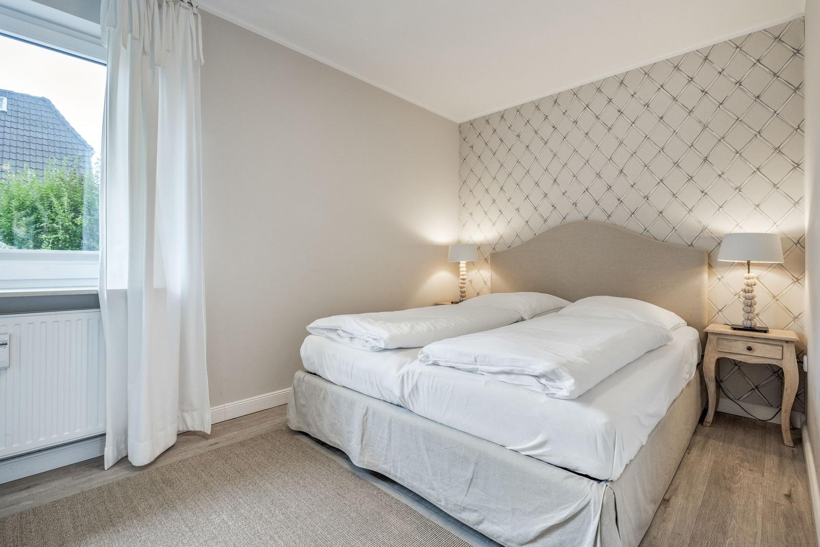 Bedroom with double bed, window and bedside table