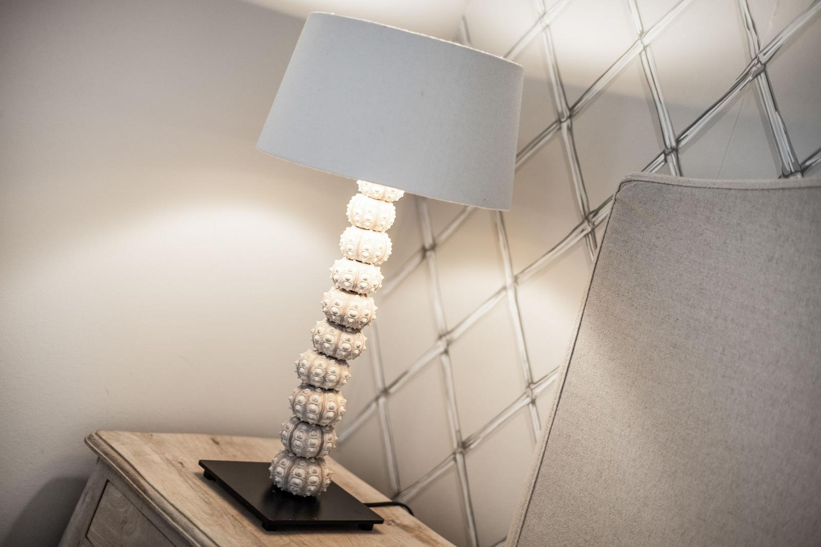 Table lamp with ball base on nightstand beside chair