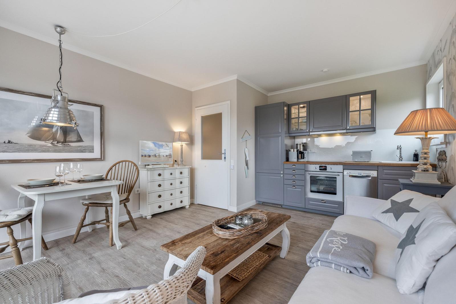 Living kitchen with sofa, dining table, and kitchen cabinets.