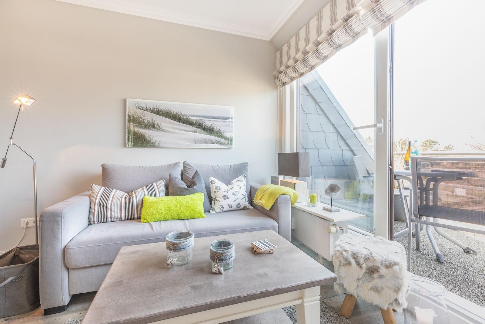 Ein Wohnzimmer mit Sofa, Couchtisch und Balkonansicht.