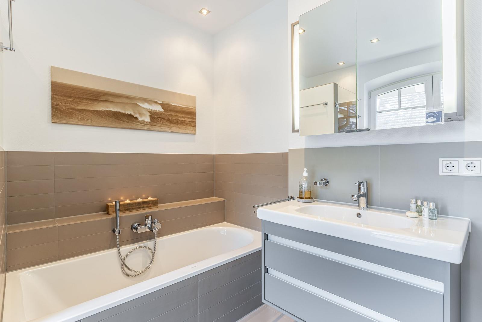 Bathroom with bathtub, sink, and mirror.