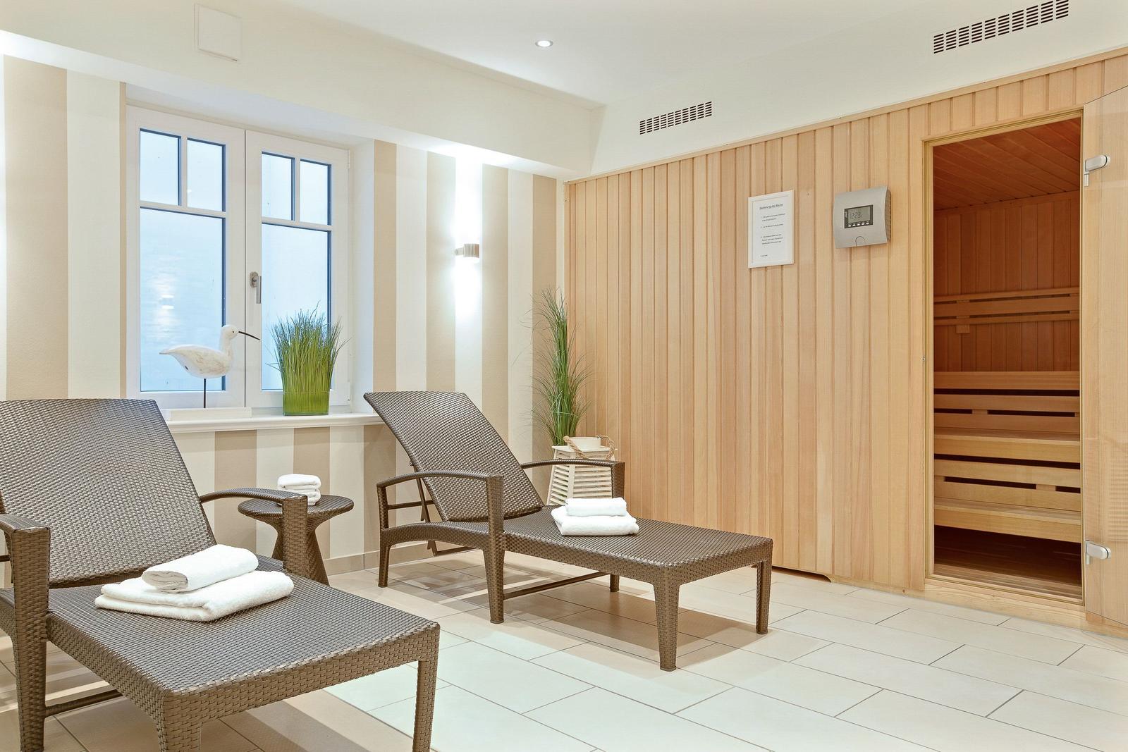 Sauna room with two lounge chairs and view of water