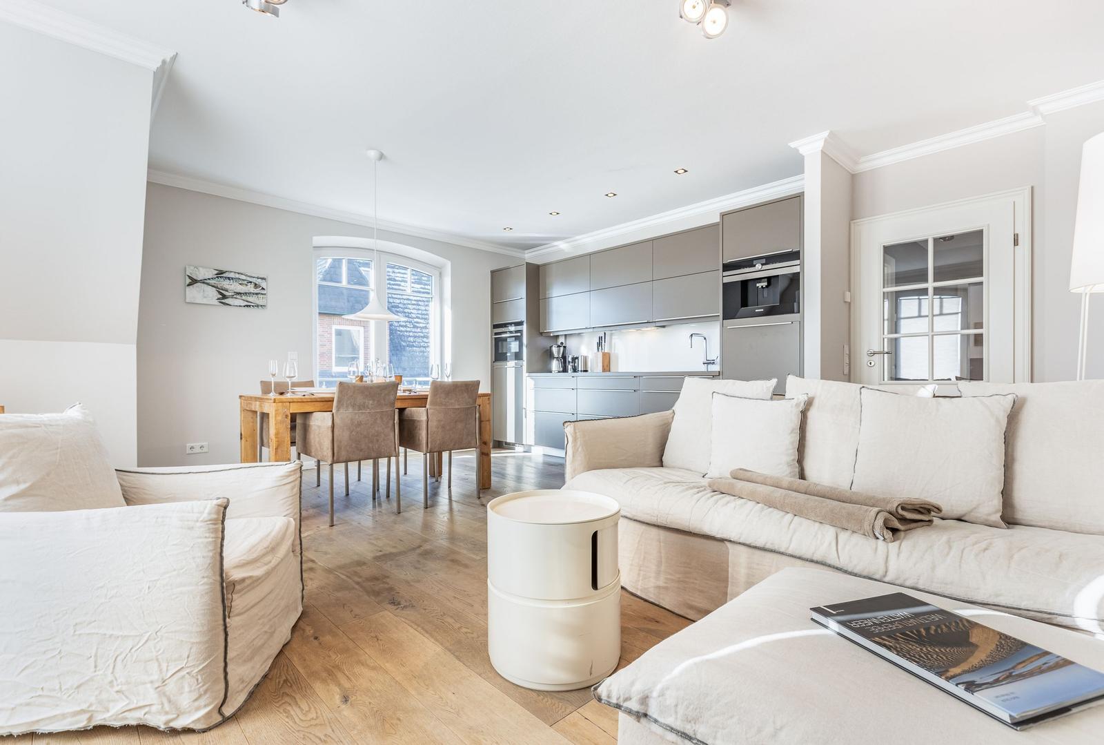 Living and dining area with modern kitchen and wooden floor.