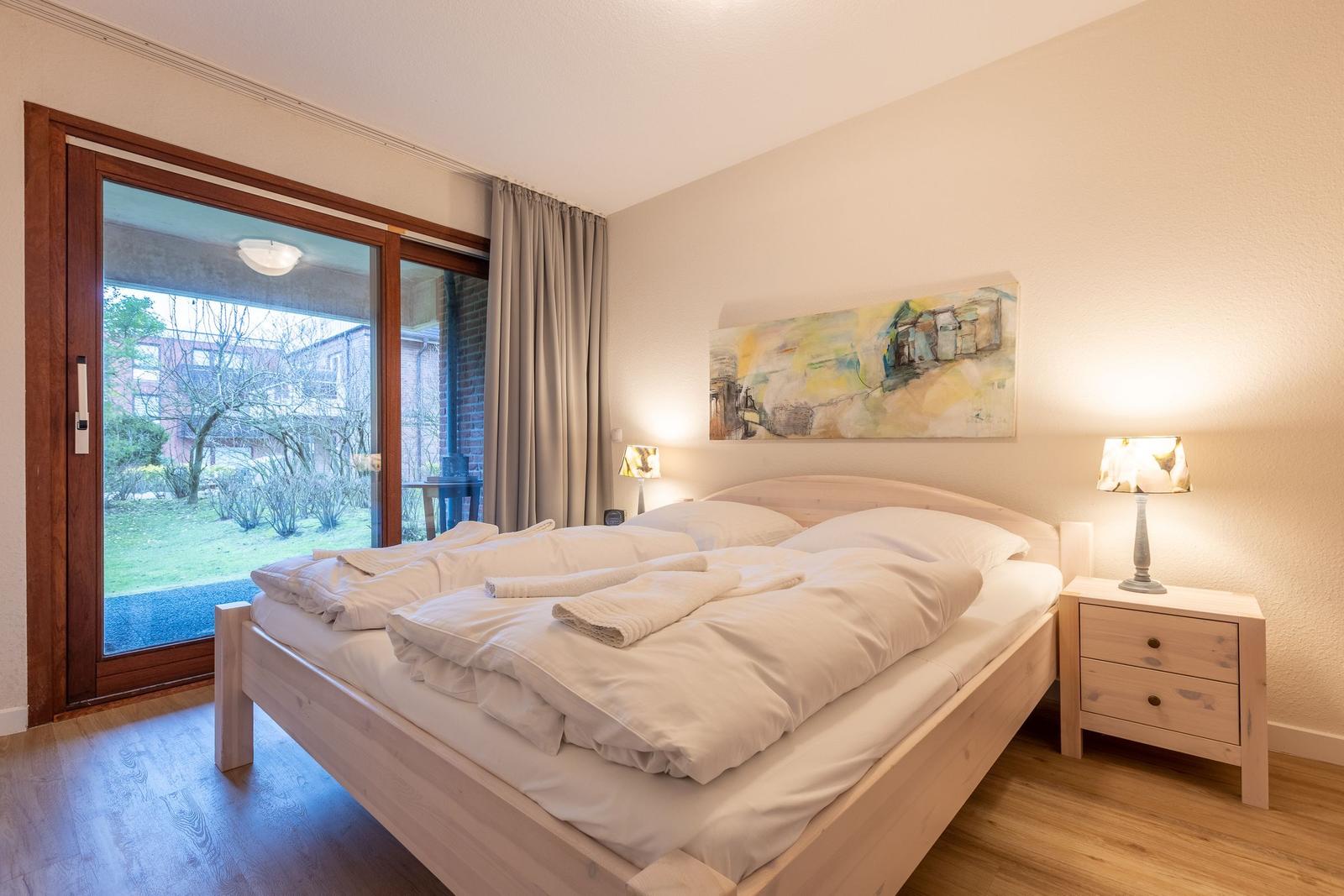 Bedroom with double bed, nightstand, and window to terrace.