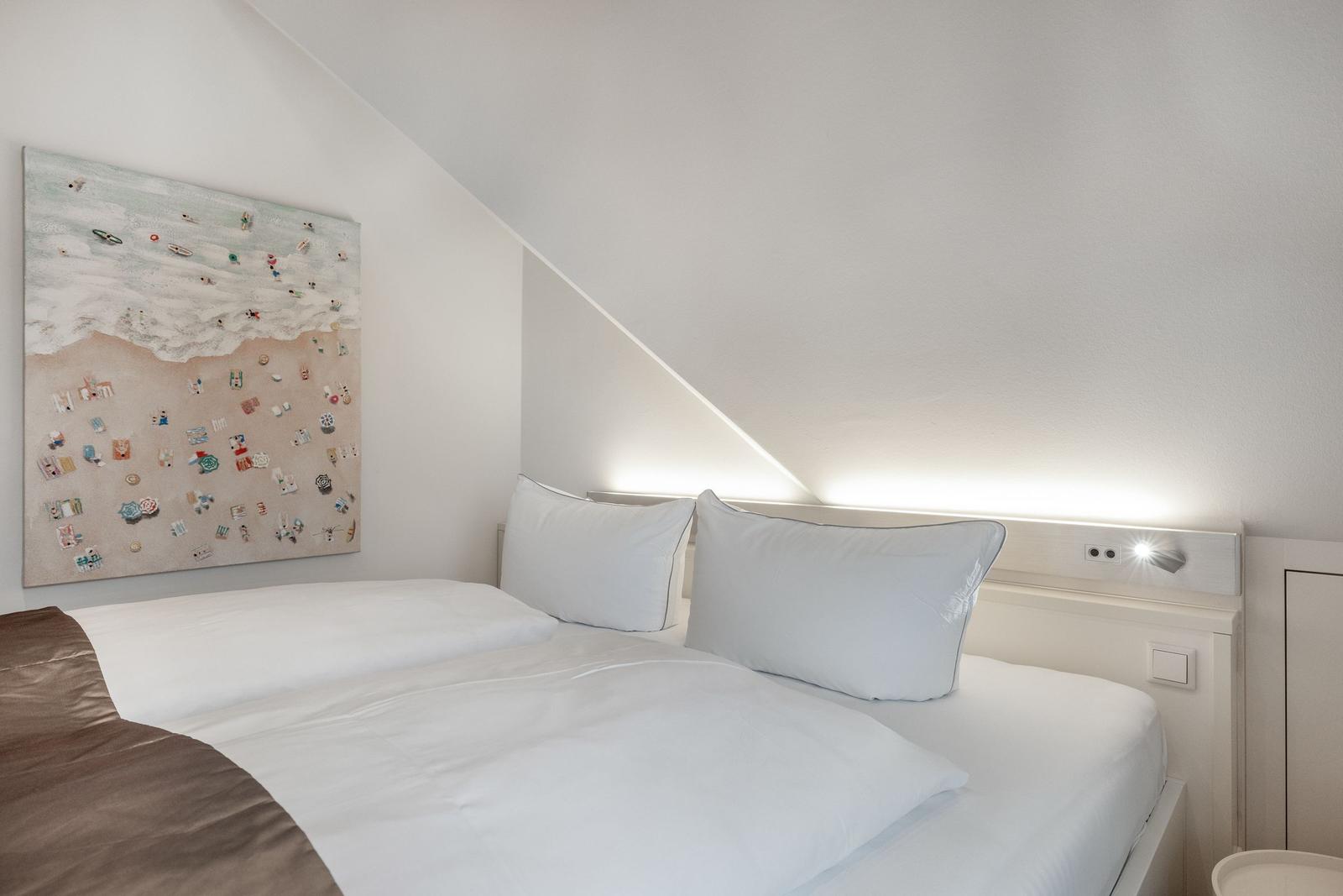 Schlafzimmer mit Bett, Wandbild und schrägem Dach