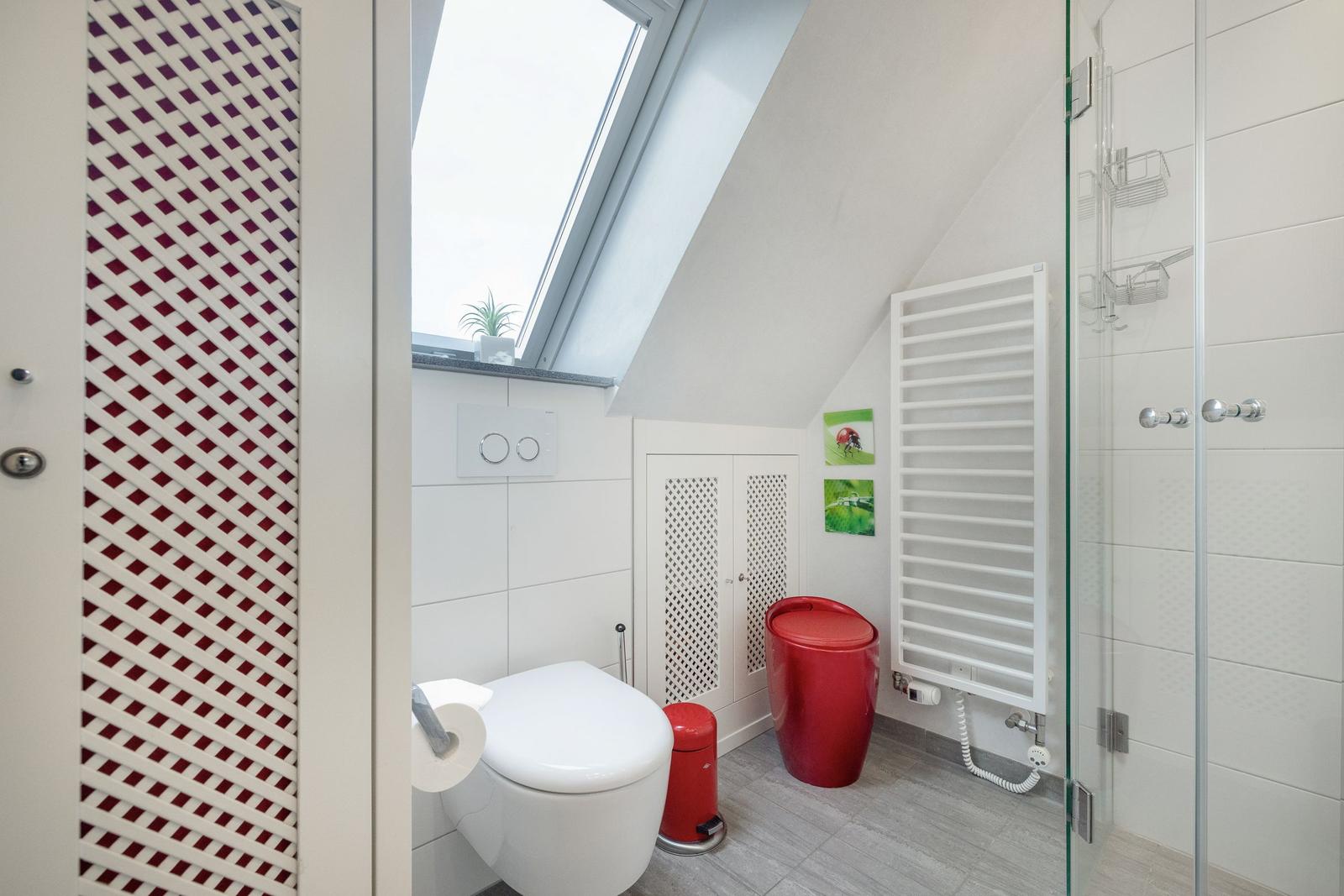 Badezimmer mit Dusche, Toilette und Fenster