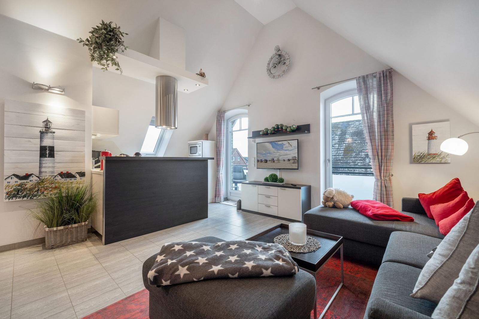 Wohnküche mit Schlafcouch, Fernseher und Fenster mit Blick.