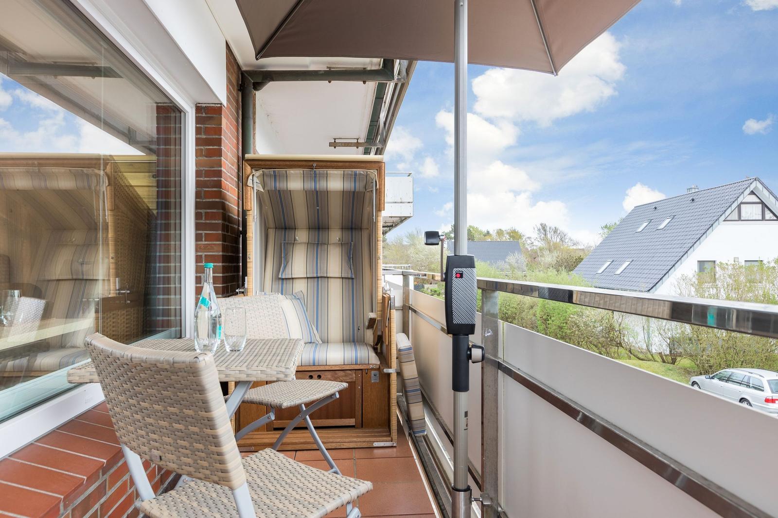 Terrace with seating, umbrella, and view of residential house