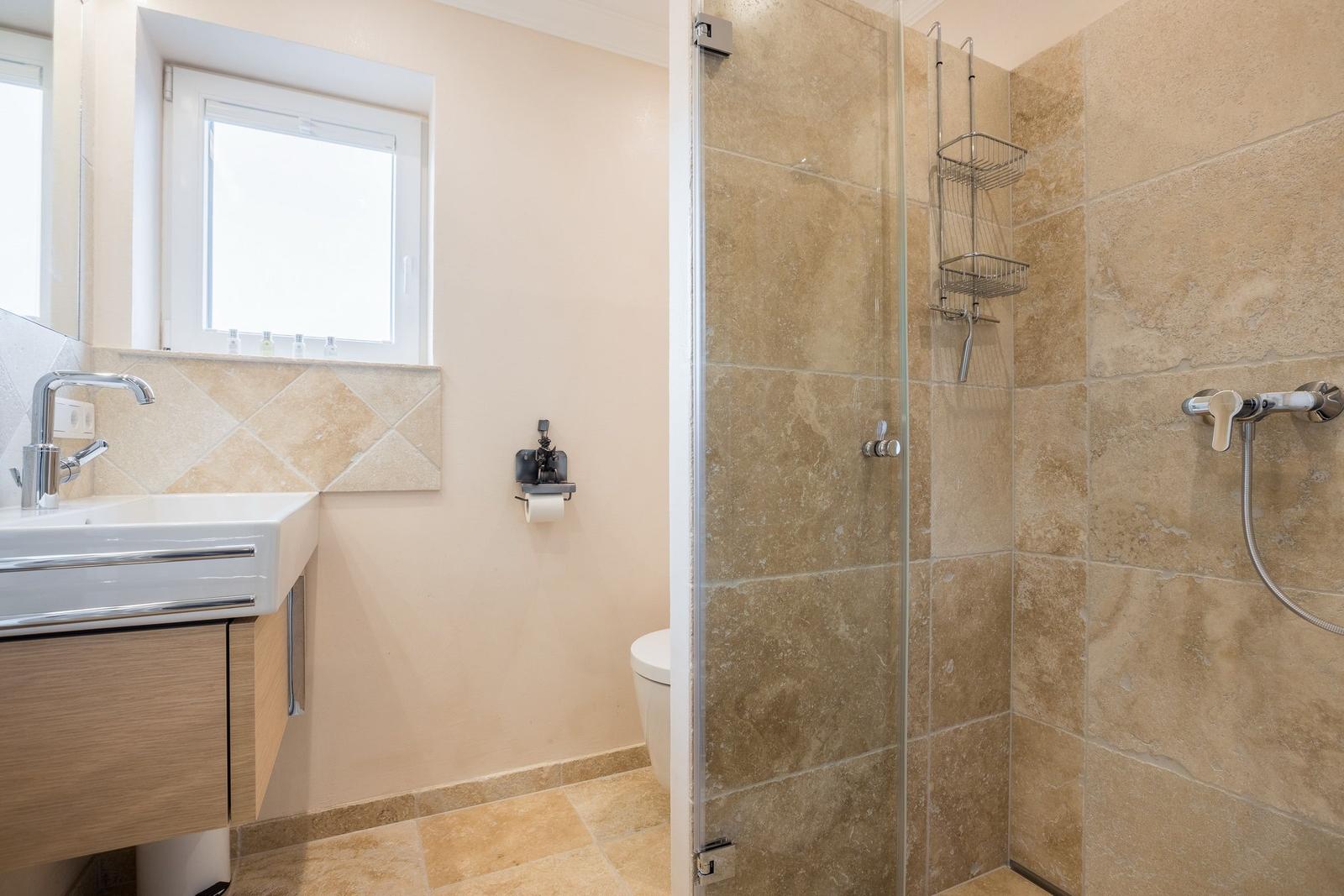Bathroom with shower, sink, and toilet.