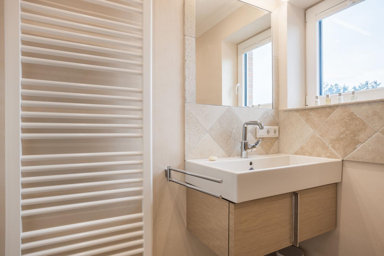 Bathroom with sink, mirror, and heater.