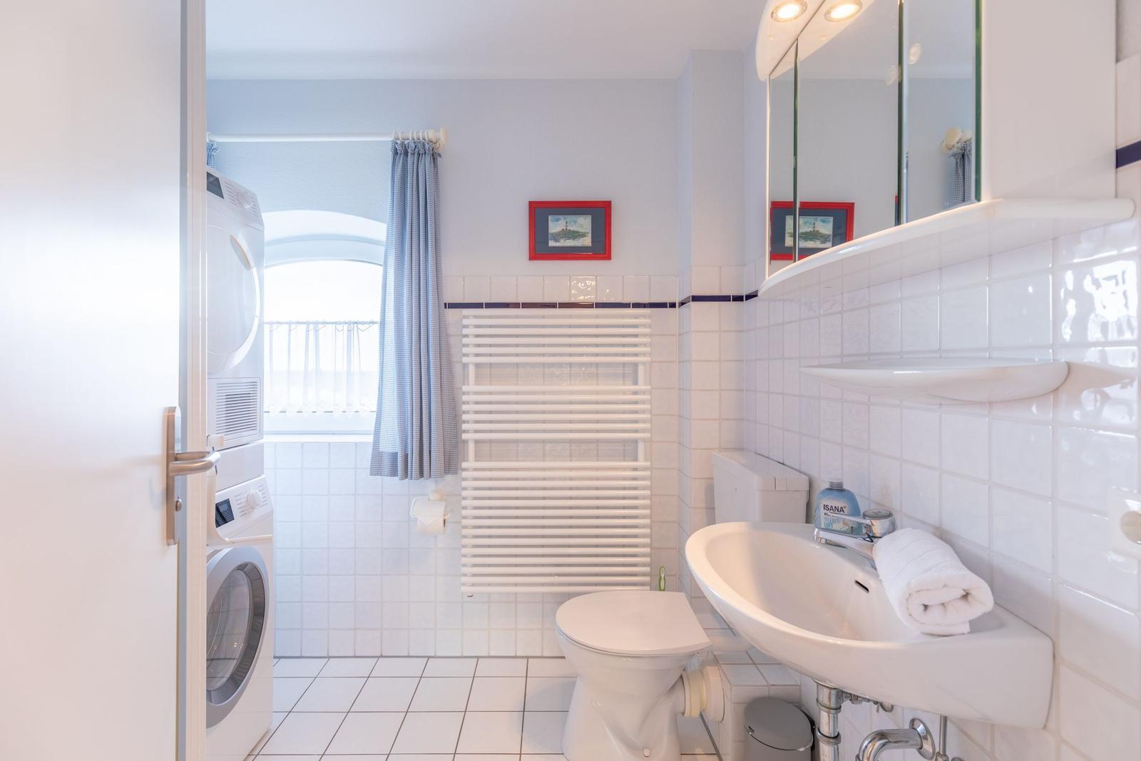 Badezimmer mit Waschmaschine, Toilette und Waschbecken