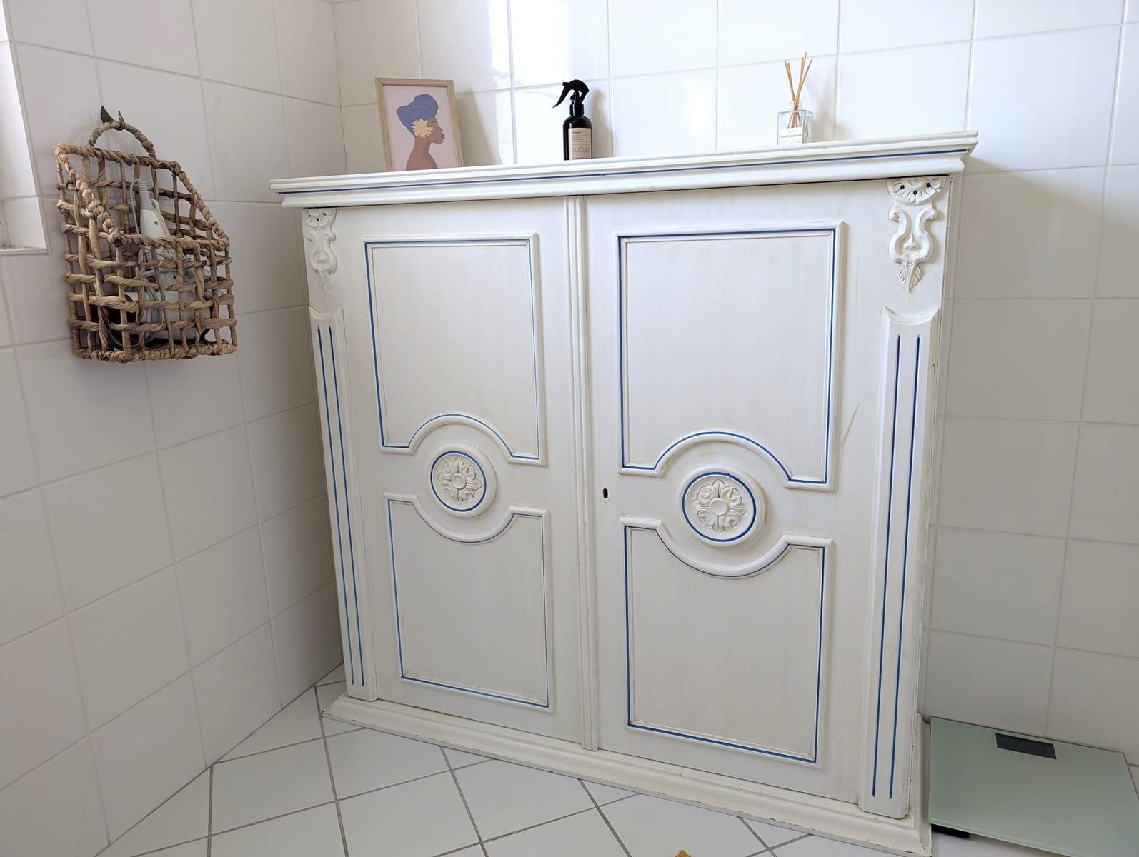 Weißer Schrank mit blauen Akzenten in Badezimmer
