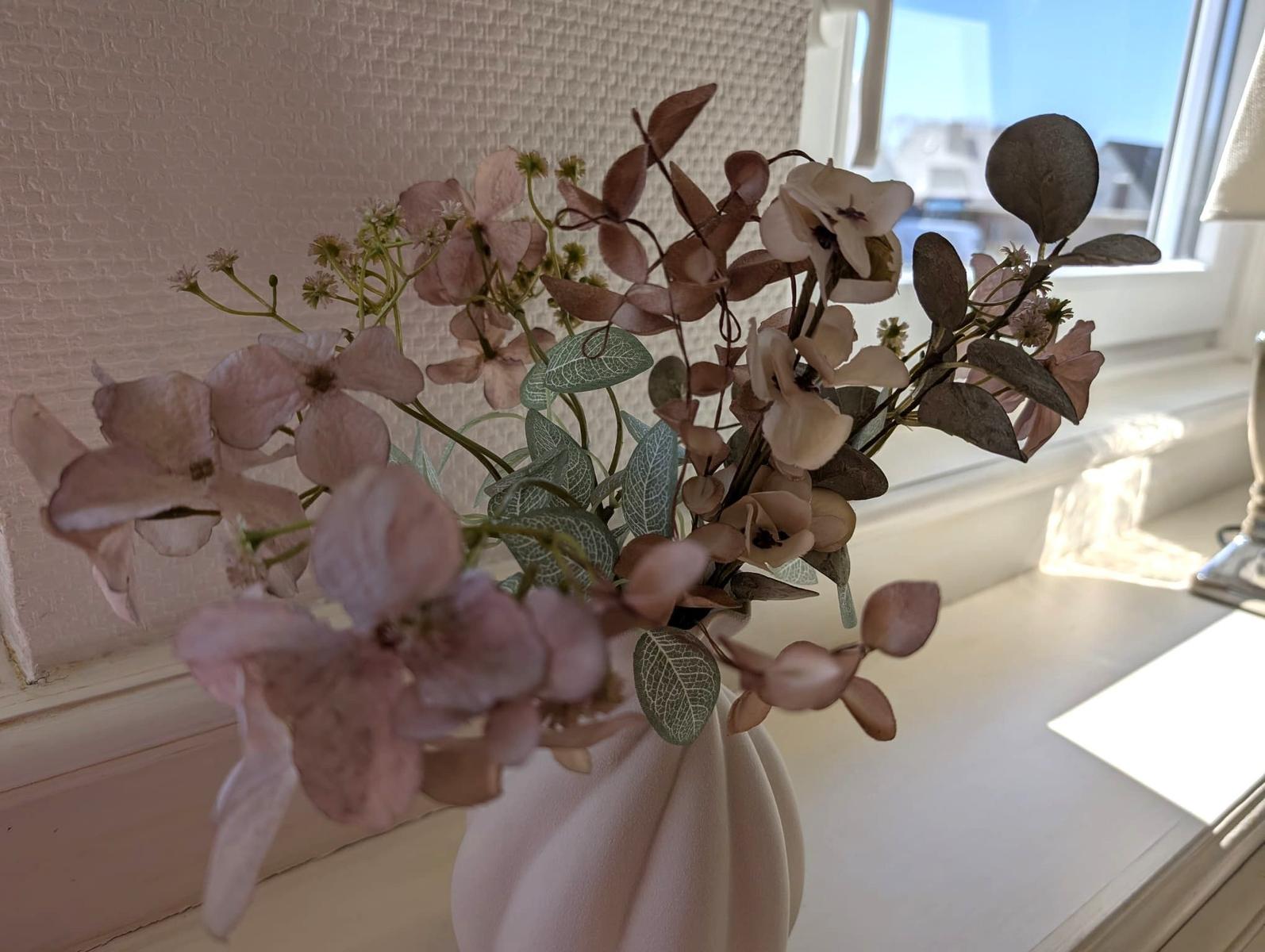 Blumenstrauß in Vase auf Fensterbank