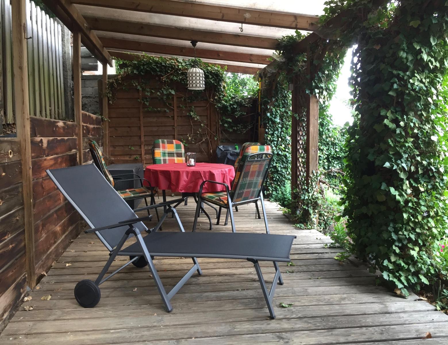 Großzügige, überdachte Terrasse für erholsame Stunden – ein Holzkohlengrill ist ebenfalls vorhanden.