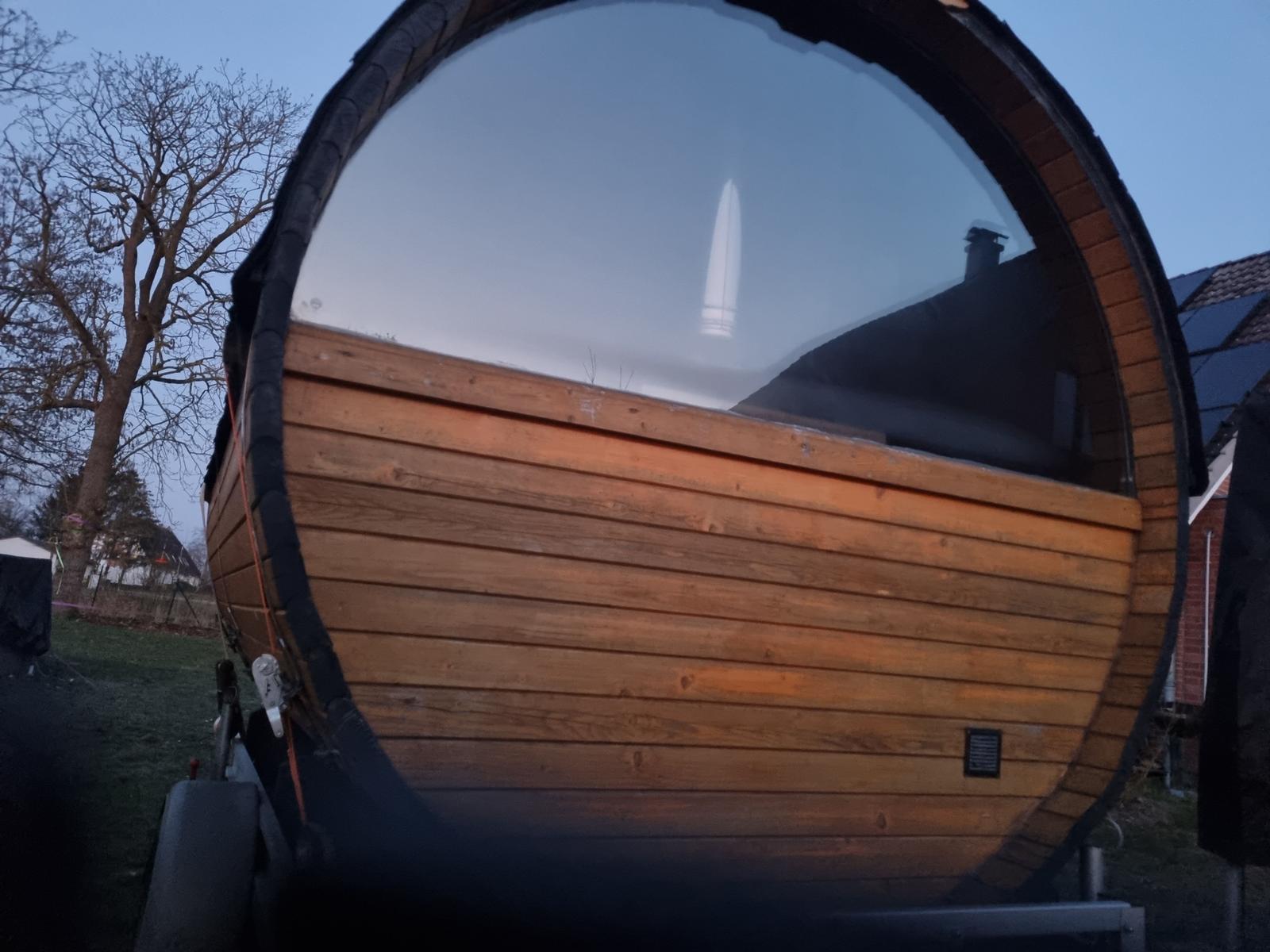 Private Wellnessmomente in unserer stilvollen Fasssauna mit Panoramafenster im Garten – inklusive verschiedener Duftaufgüsse.
