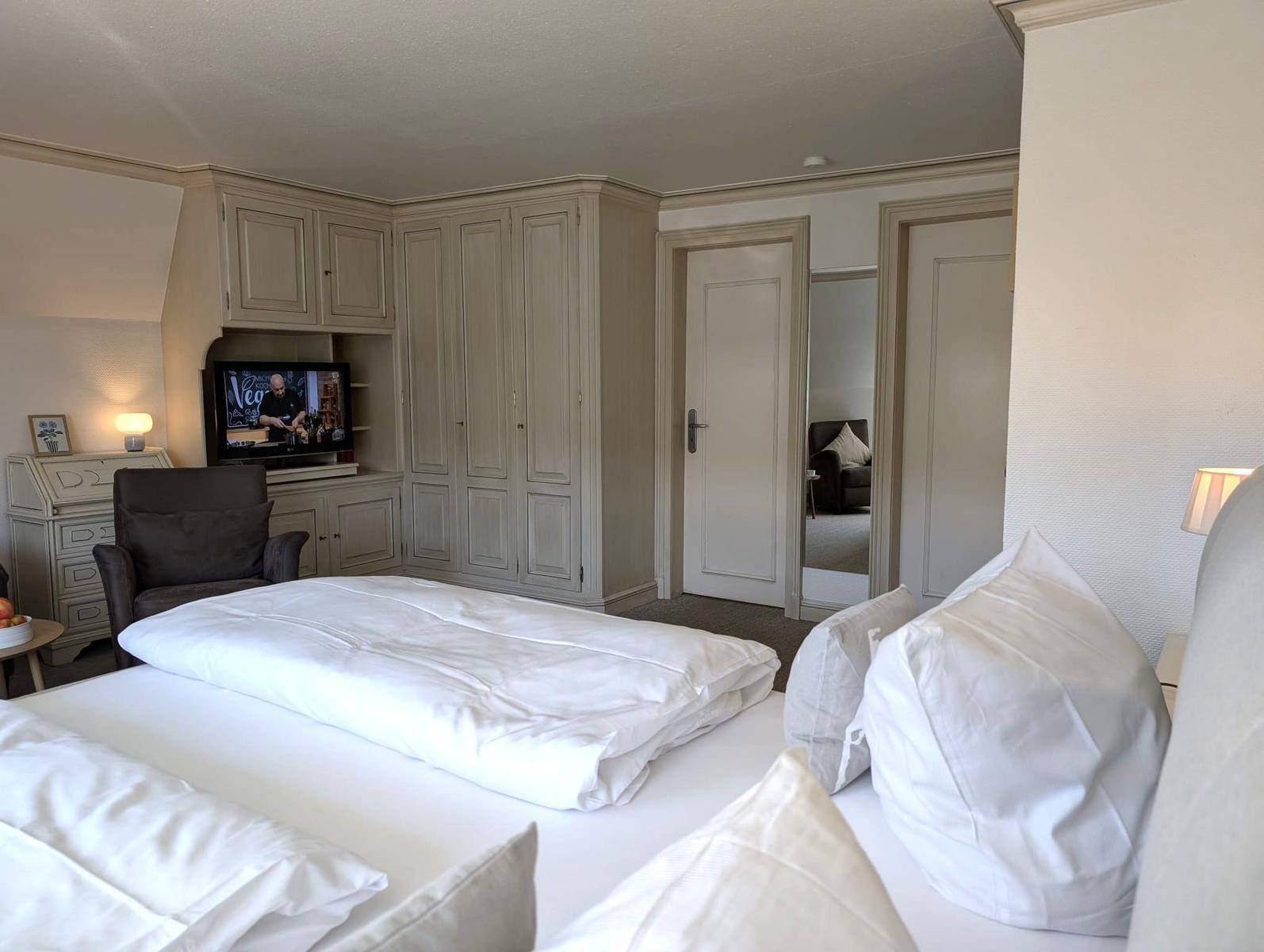 Schlafzimmer mit Bett, Kleiderschrank und Fernseher