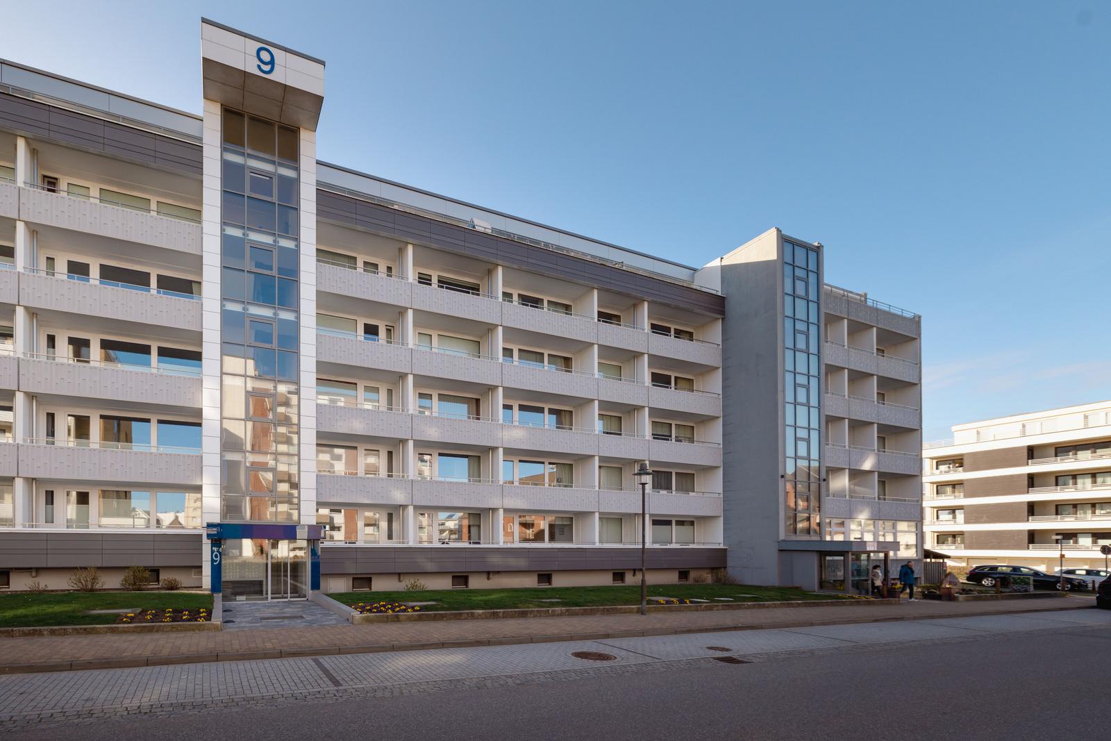 Modernes Mehrfamilienhaus mit Balkonen und Glasfassade. Nummer 9.