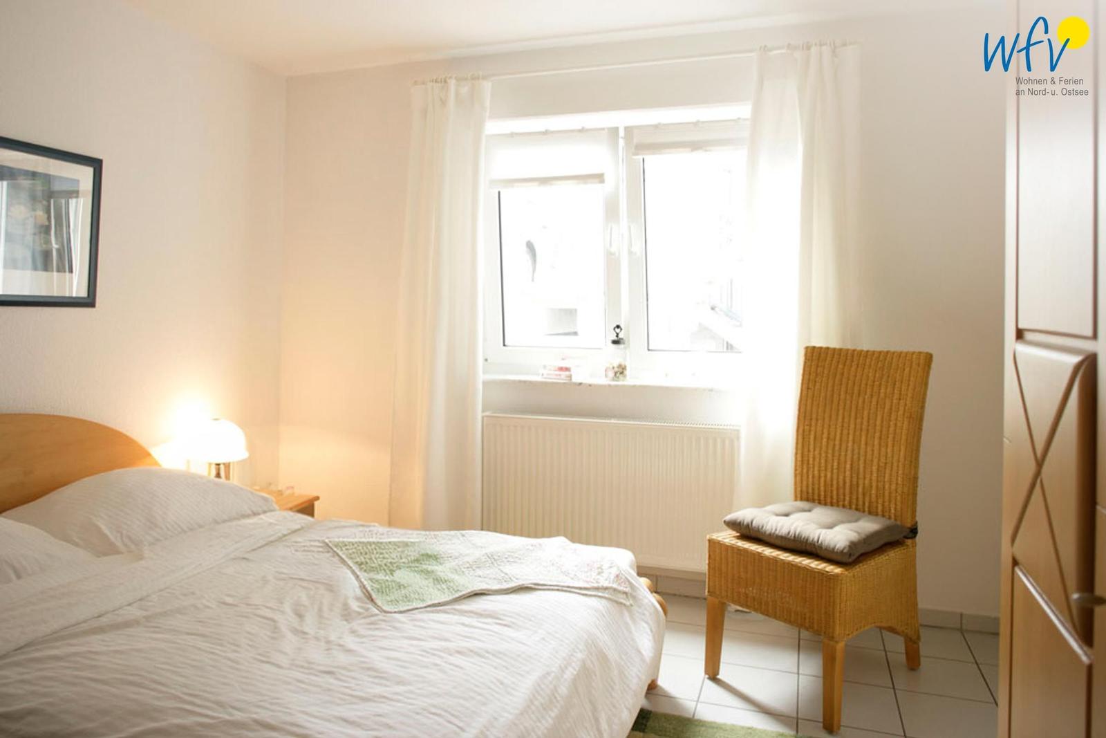 Schlafzimmer mit Bett, Stuhl und Fenster