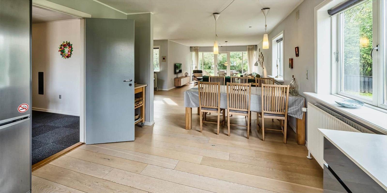 Essbereich mit Holztisch und Stühlen. Durchgang zu Wohnzimmer und Küche.