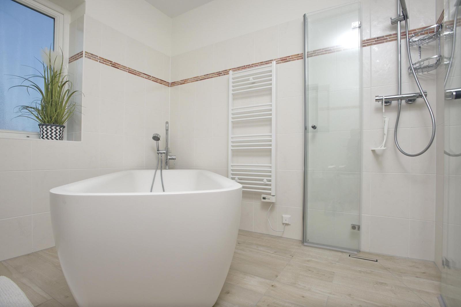 Bad mit freistehender Badewanne, Dusche und Heizkörper