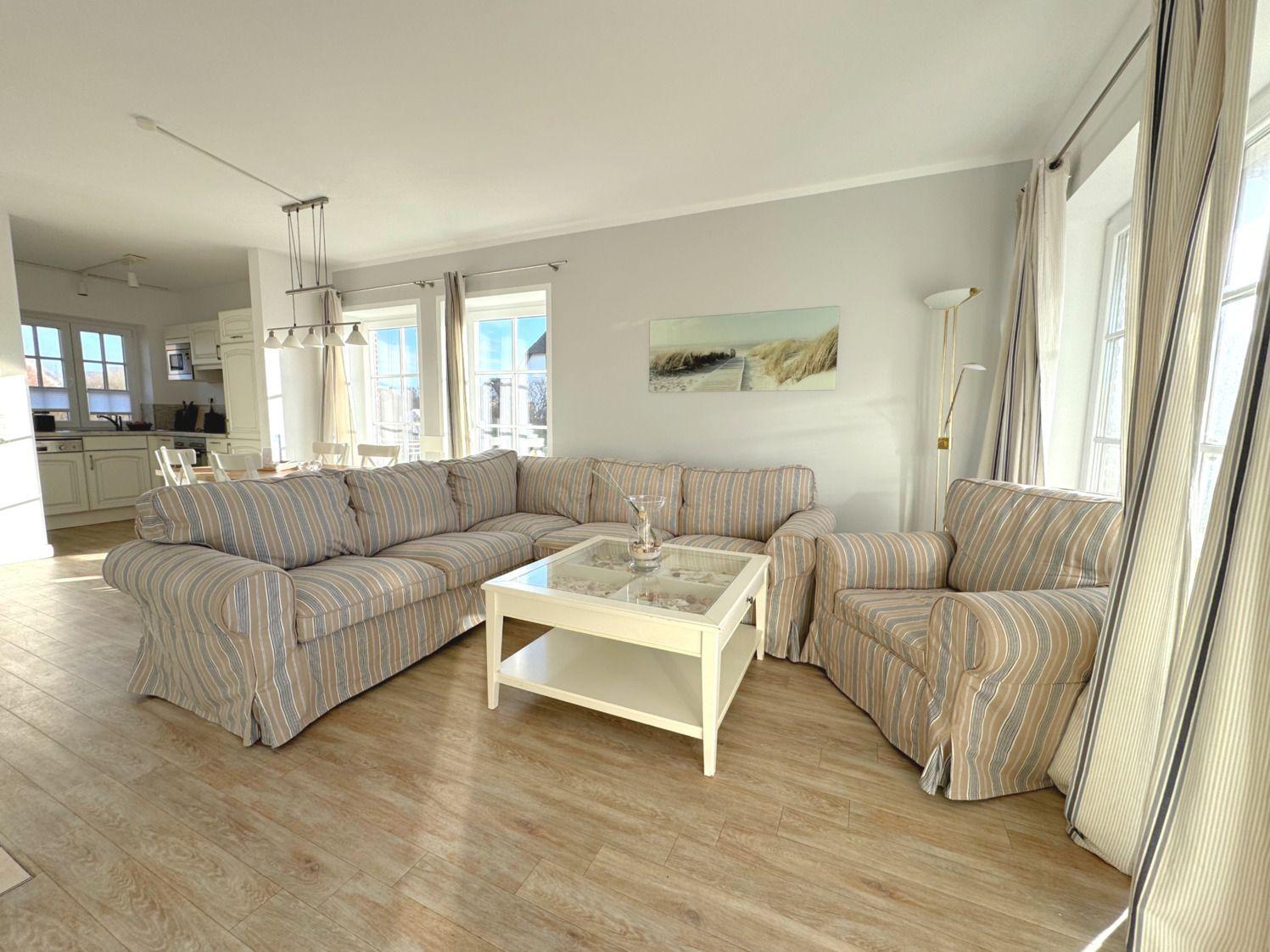 Wohn- und Essbereich mit Sofa, Tisch und Küchenbereich.