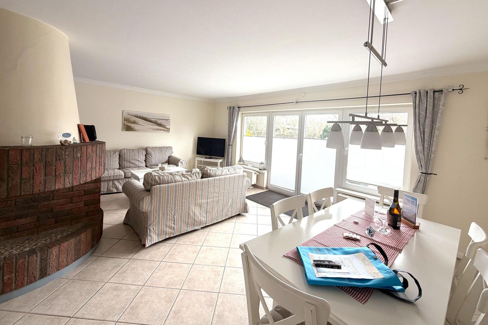 Wohn- und Essbereich mit Sofa, Esstisch und Kamin